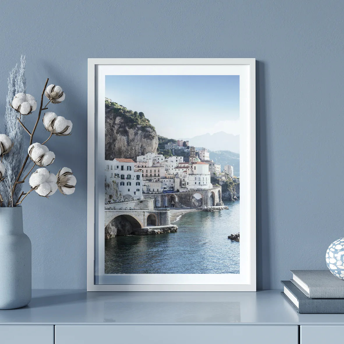 Wall art of a Mediterranean coastal town with historic white buildings and sea arches in daylight