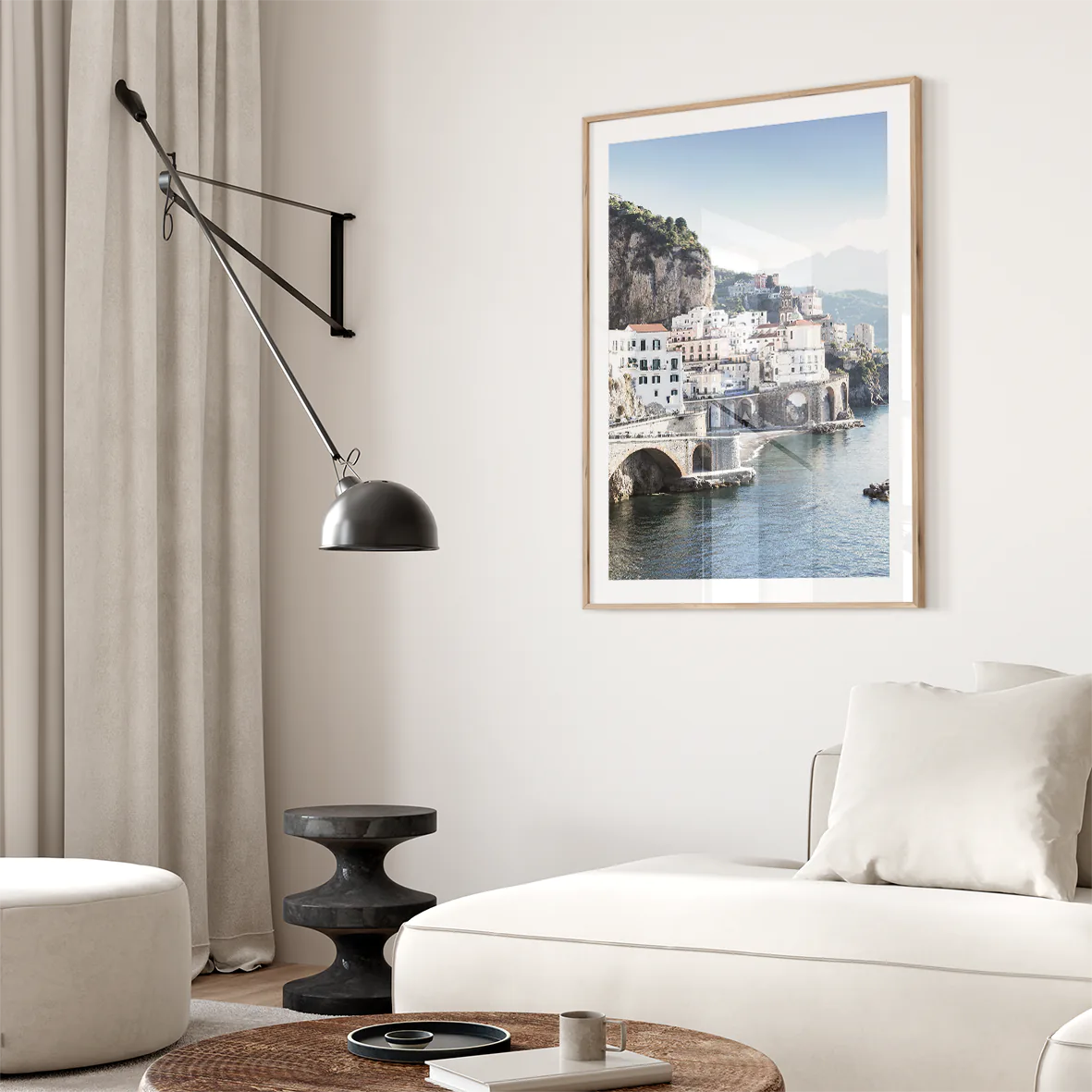 Wall art of a Mediterranean coastal town with historic white buildings and sea arches in daylight