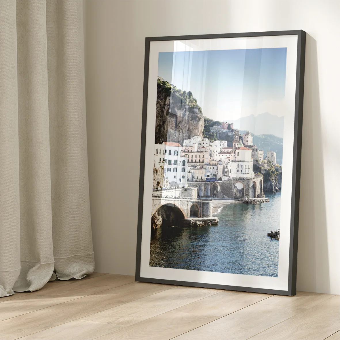 Wall art of a Mediterranean coastal town with historic white buildings and sea arches in daylight