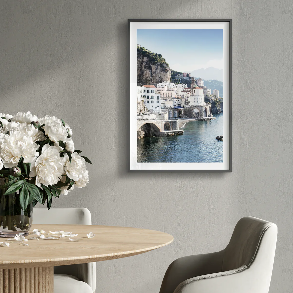 Wall art of a Mediterranean coastal town with historic white buildings and sea arches in daylight
