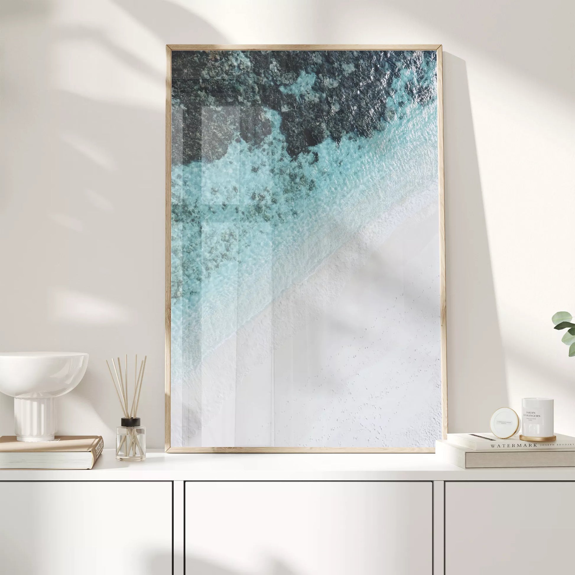 空撮で撮影された白い砂浜とターコイズブルーの海が織りなす美しいグラデーション。深い青から透明な水へと変化する海の色彩と、真っ白な砂浜のコントラストが印象的なアート写真。