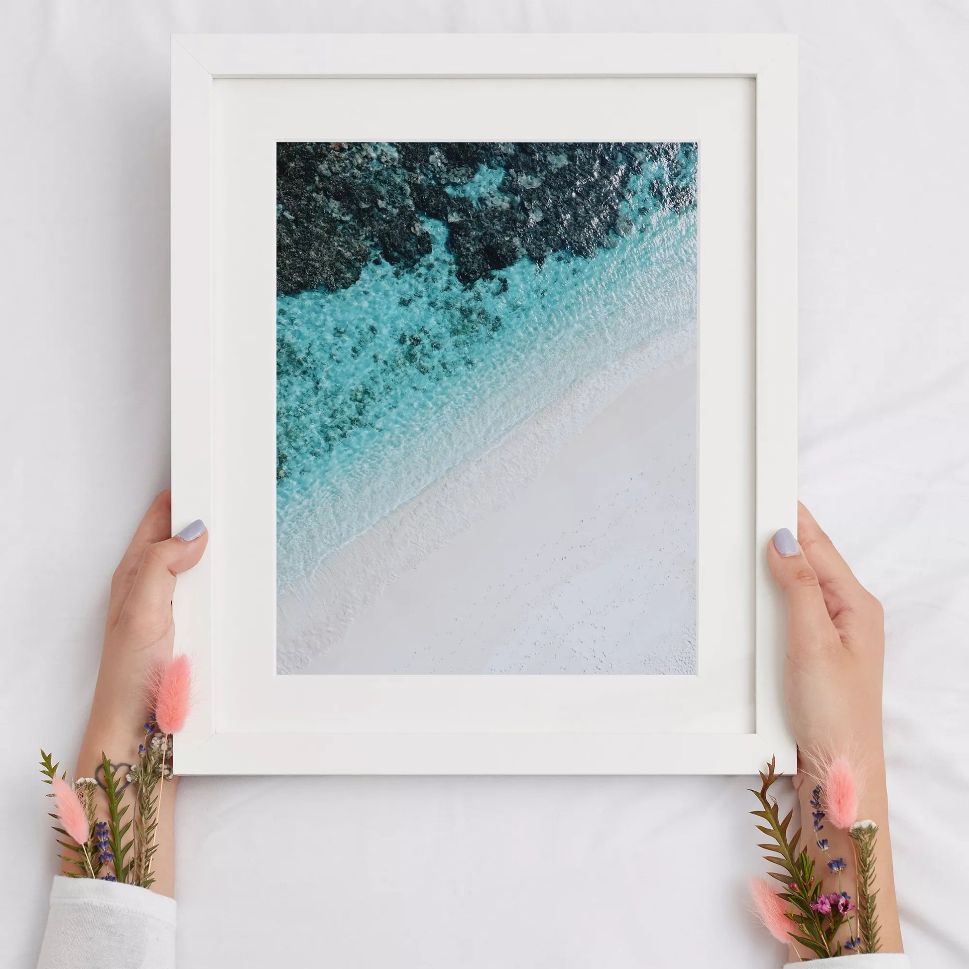 空撮で撮影された白い砂浜とターコイズブルーの海が織りなす美しいグラデーション。深い青から透明な水へと変化する海の色彩と、真っ白な砂浜のコントラストが印象的なアート写真。