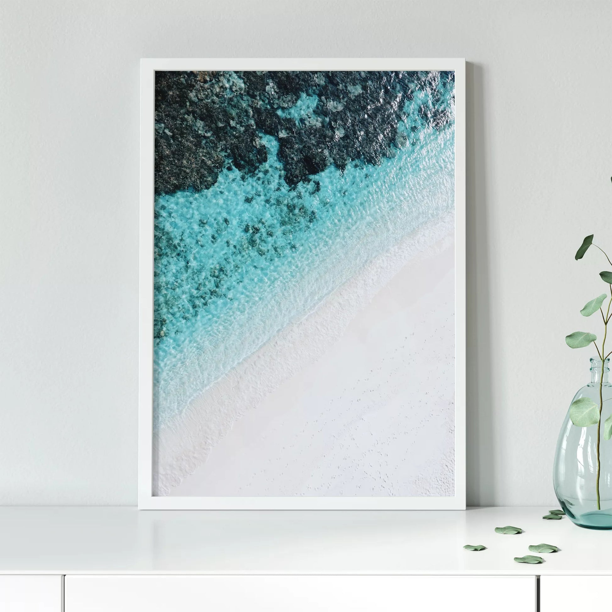 空撮で撮影された白い砂浜とターコイズブルーの海が織りなす美しいグラデーション。深い青から透明な水へと変化する海の色彩と、真っ白な砂浜のコントラストが印象的なアート写真。