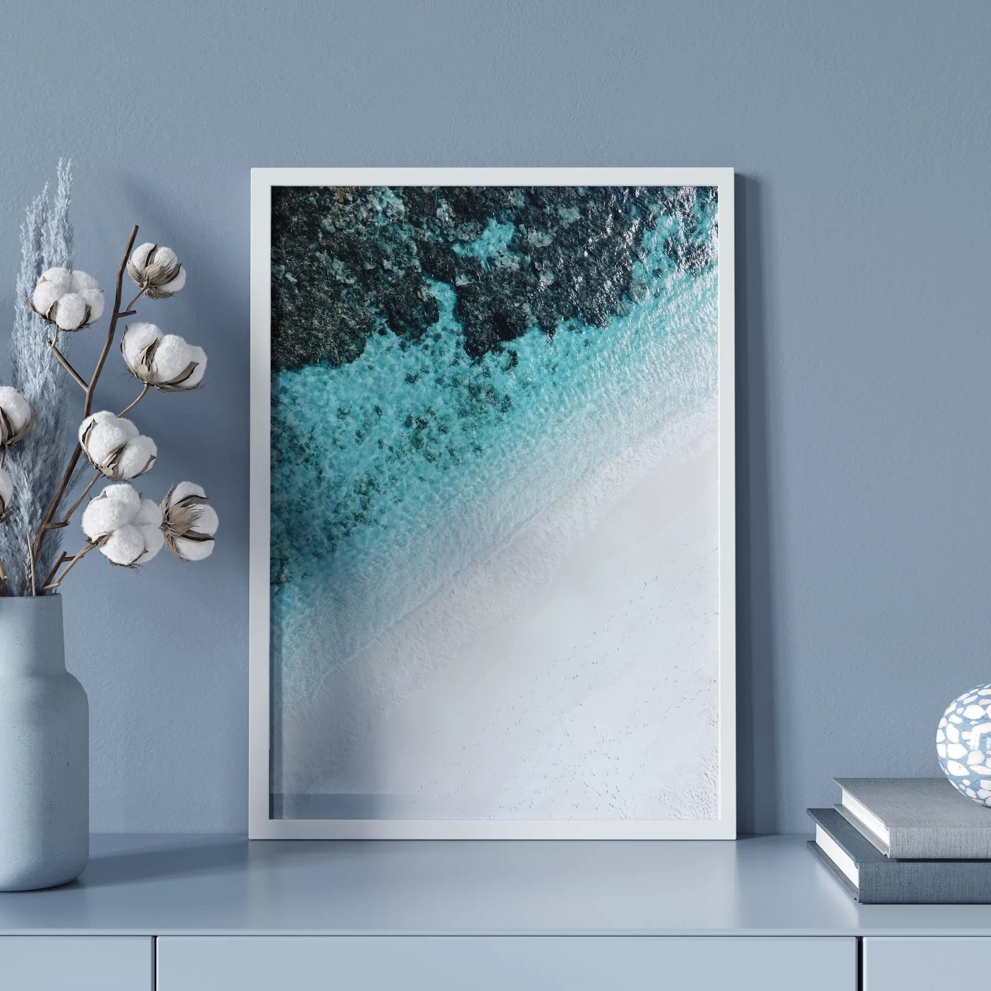 空撮で撮影された白い砂浜とターコイズブルーの海が織りなす美しいグラデーション。深い青から透明な水へと変化する海の色彩と、真っ白な砂浜のコントラストが印象的なアート写真。