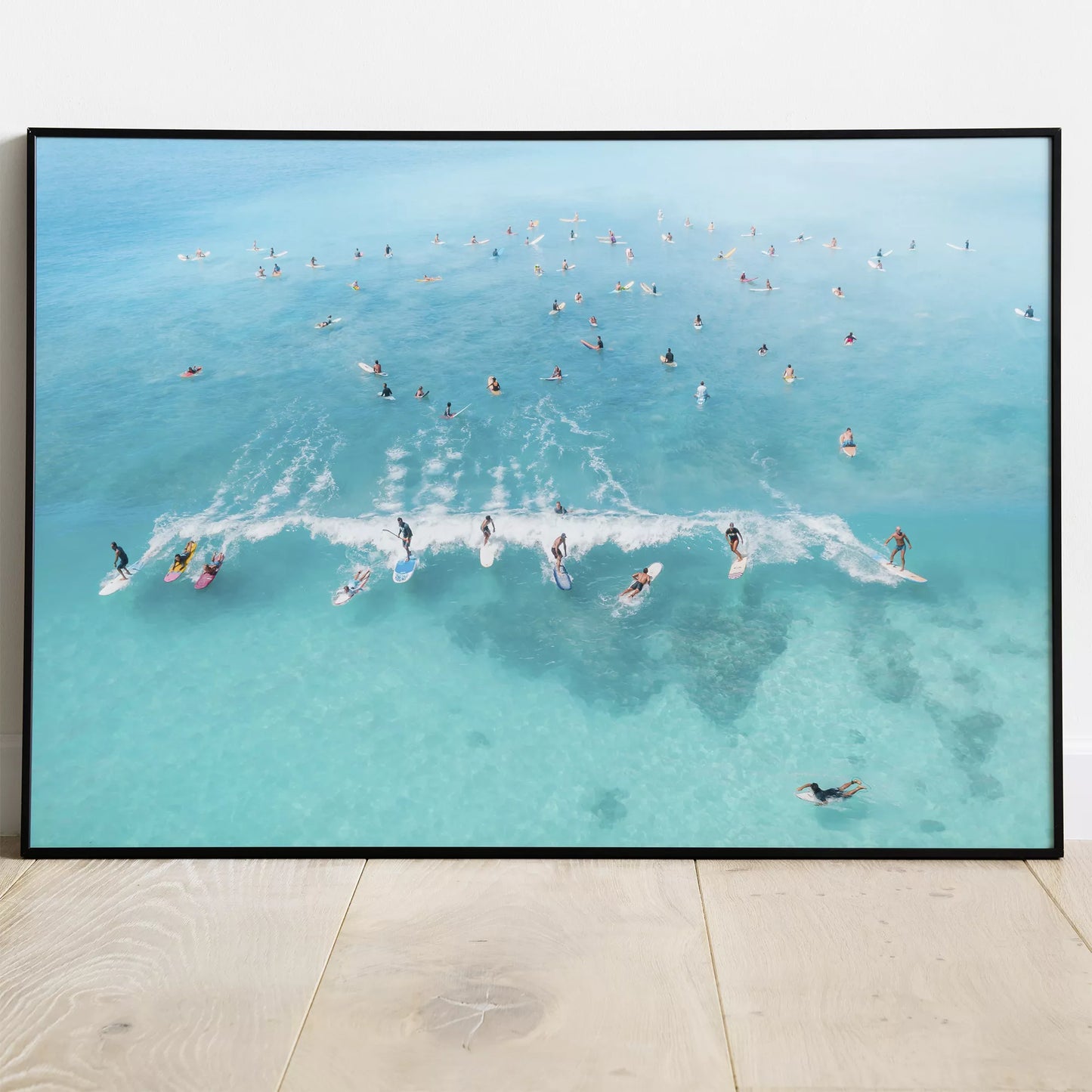 エメラルドブルーの海でサーフィンを楽しむ人々を捉えた空撮アート