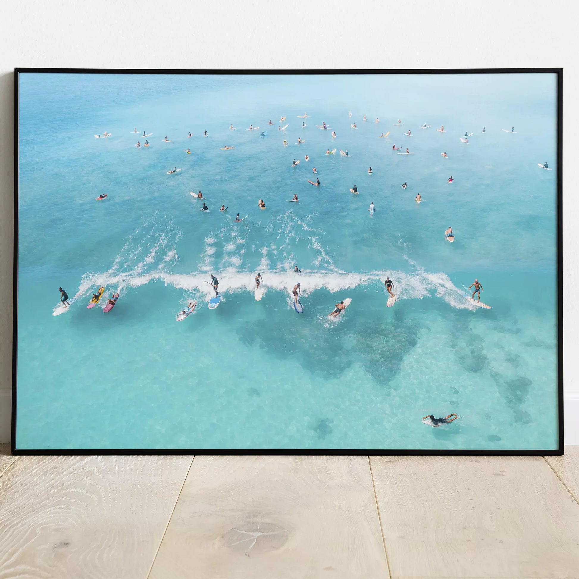 エメラルドブルーの海でサーフィンを楽しむ人々を捉えた空撮アート