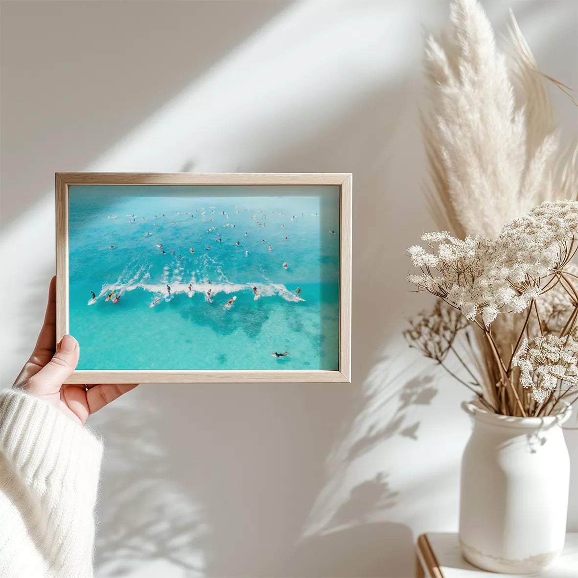 エメラルドブルーの海でサーフィンを楽しむ人々を捉えた空撮アート