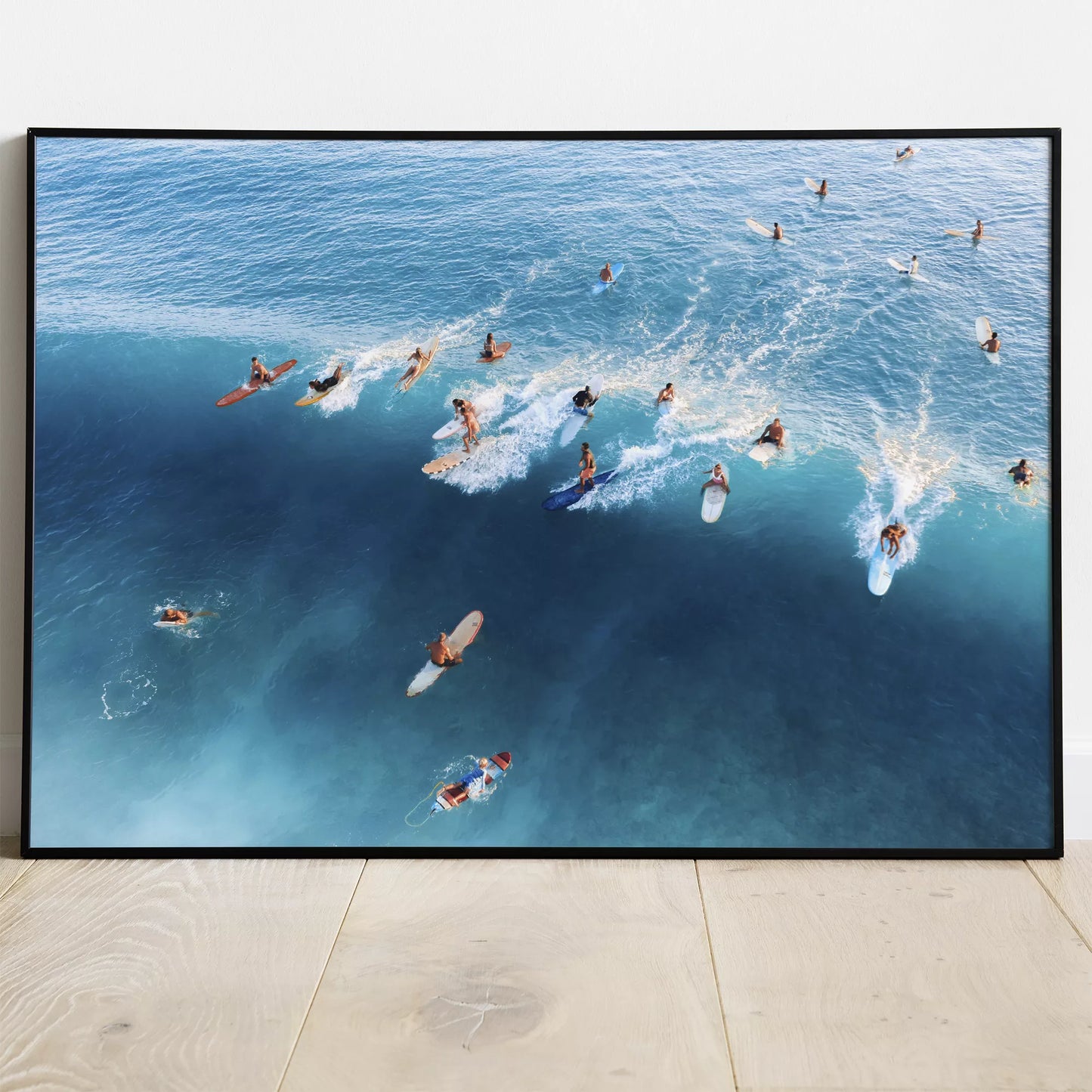 青い海でサーフィンを楽しむサーファーたちの空撮写真