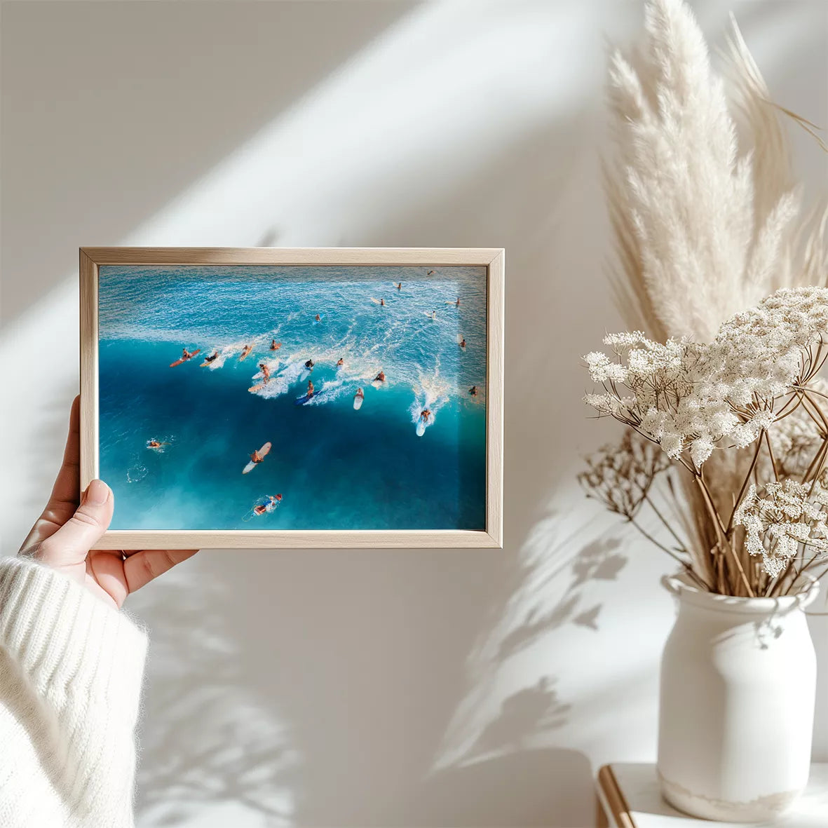 青い海でサーフィンを楽しむサーファーたちの空撮写真