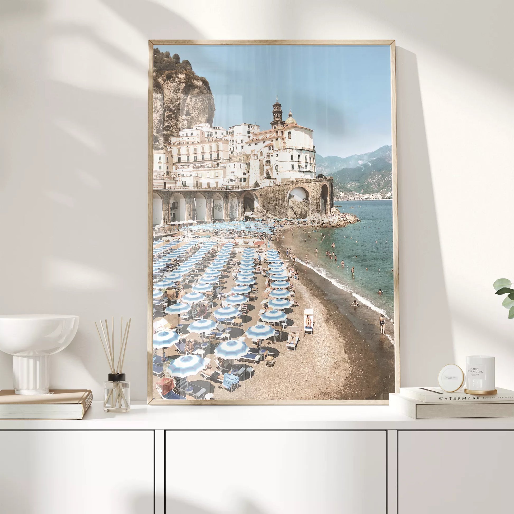 アマルフィ海岸の白壁建築と青いパラソルが並ぶビーチ風景