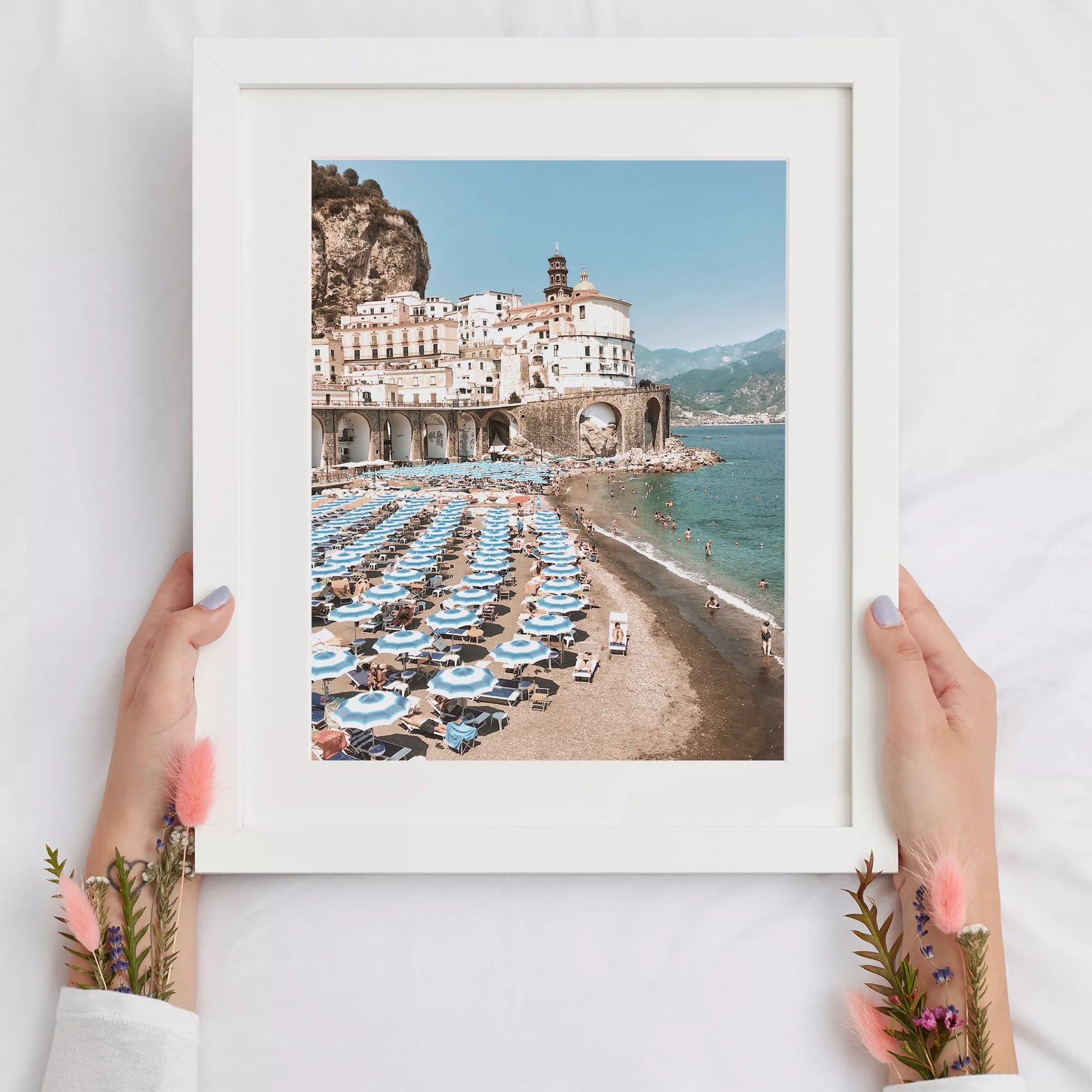 アマルフィ海岸の白壁建築と青いパラソルが並ぶビーチ風景