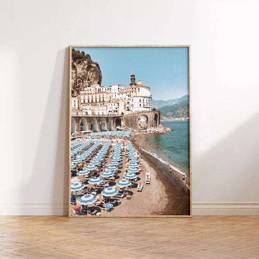 アマルフィ海岸の白壁建築と青いパラソルが並ぶビーチ風景