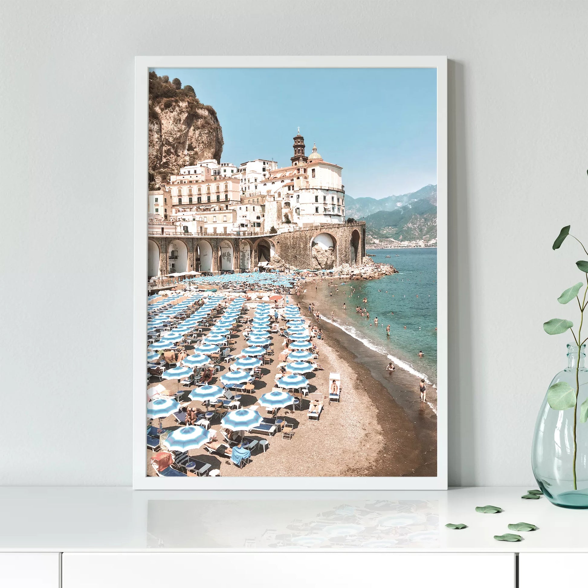 アマルフィ海岸の白壁建築と青いパラソルが並ぶビーチ風景
