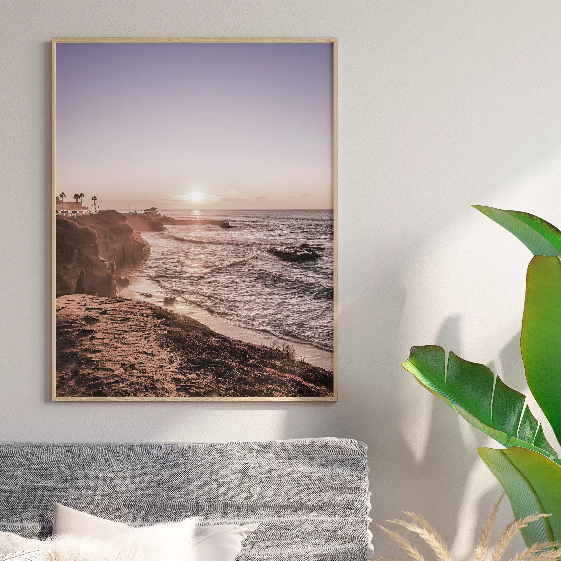 夕暮れの海岸線に沈む太陽、岩壁と波打ち際の癒しの風景