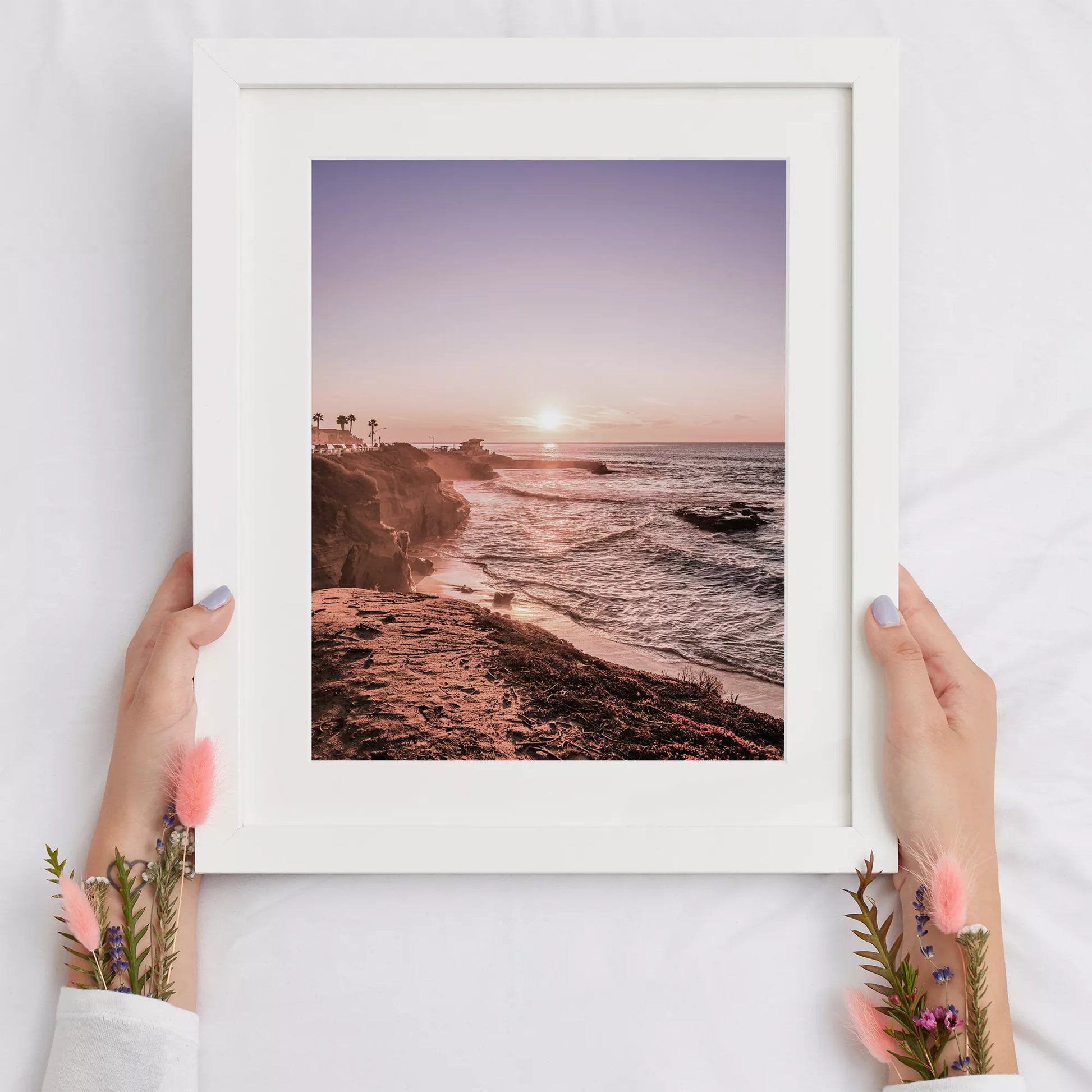 夕暮れの海岸線に沈む太陽、岩壁と波打ち際の癒しの風景