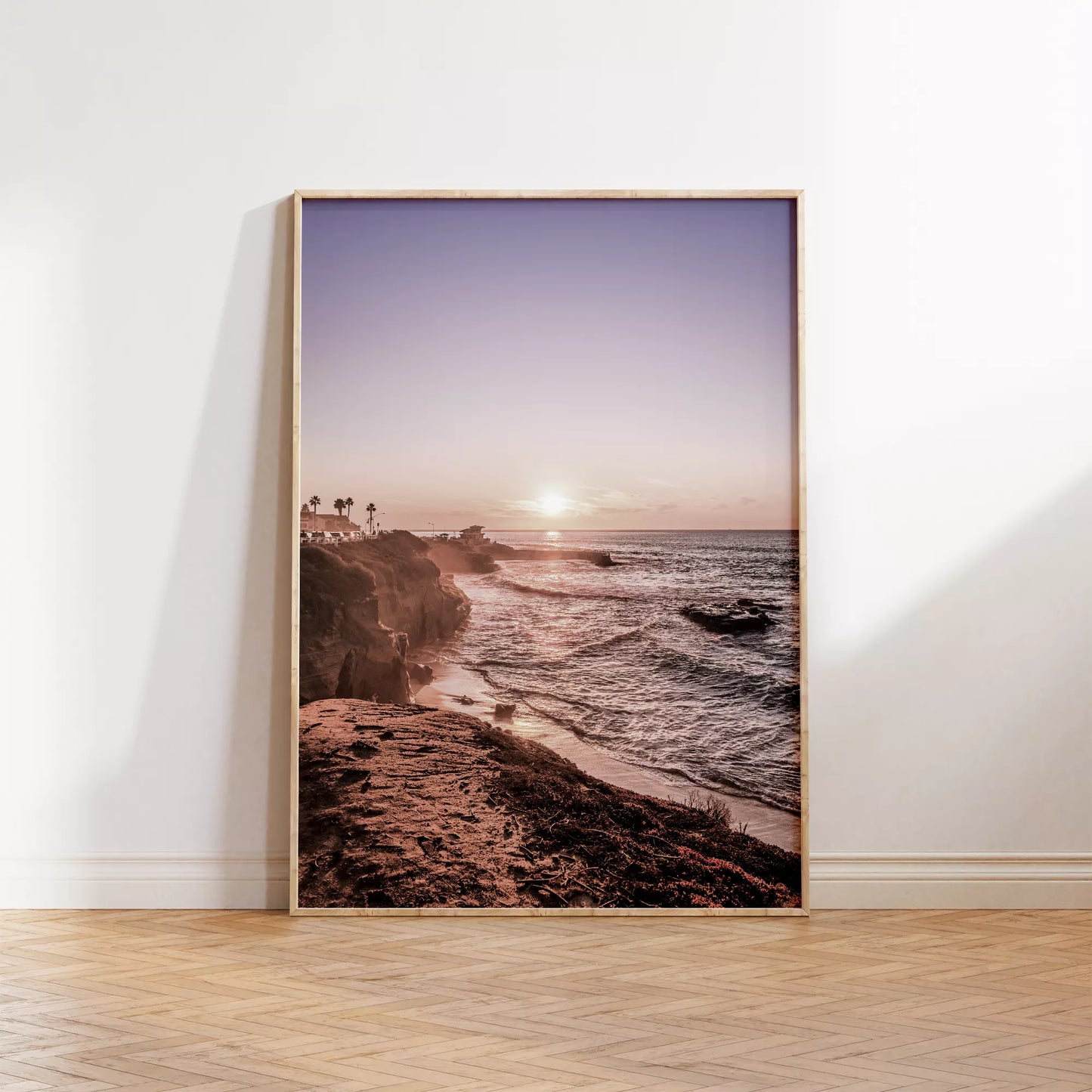 夕暮れの海岸線に沈む太陽、岩壁と波打ち際の癒しの風景