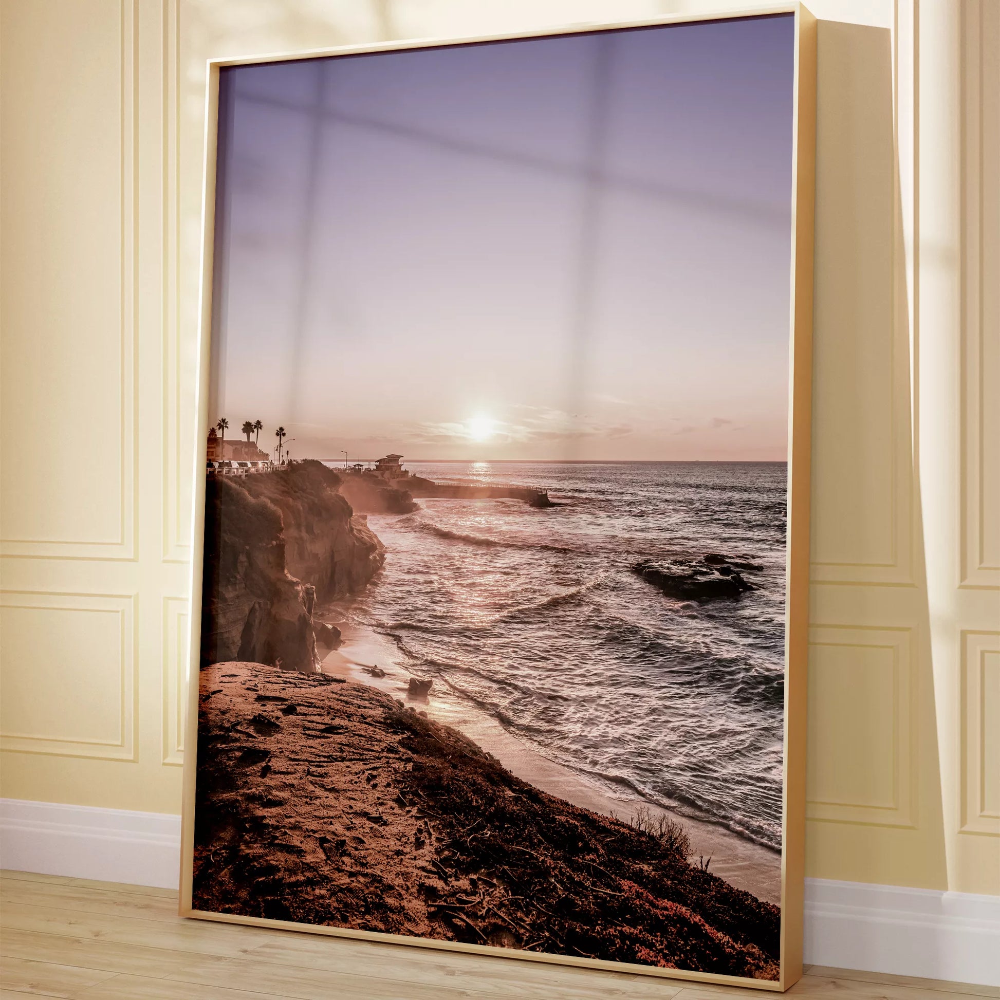 夕暮れの海岸線に沈む太陽、岩壁と波打ち際の癒しの風景