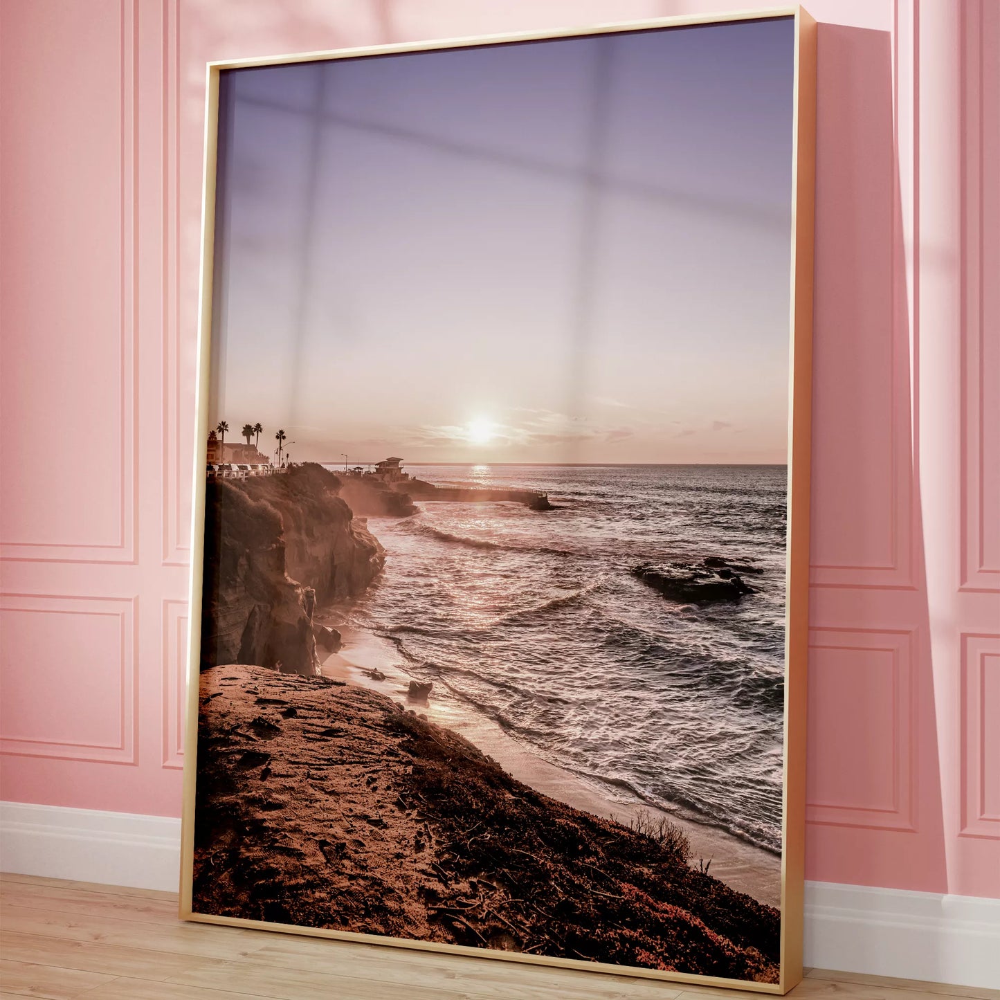 夕暮れの海岸線に沈む太陽、岩壁と波打ち際の癒しの風景