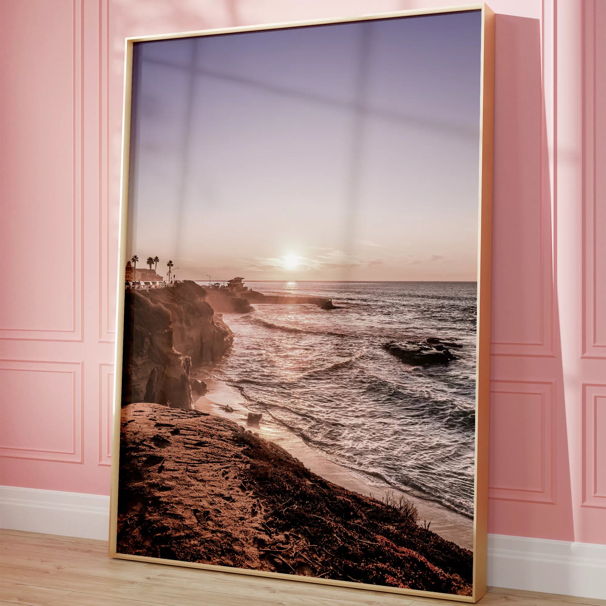 夕暮れの海岸線に沈む太陽、岩壁と波打ち際の癒しの風景