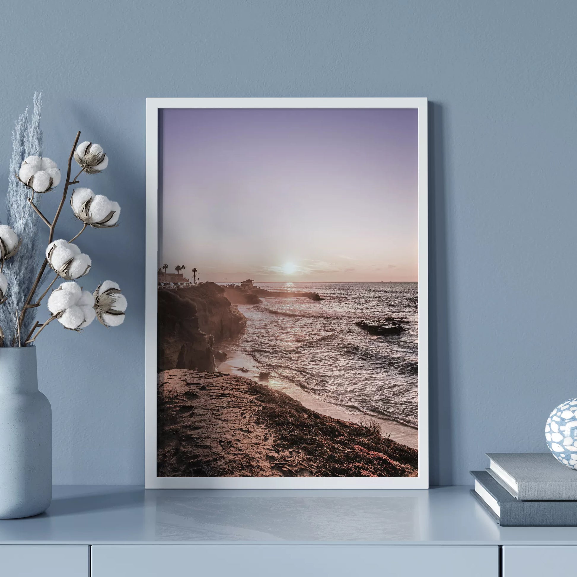 夕暮れの海岸線に沈む太陽、岩壁と波打ち際の癒しの風景