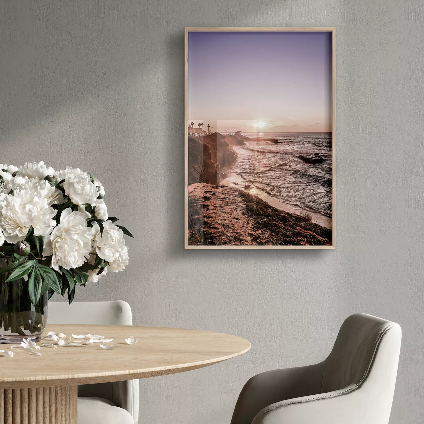 夕暮れの海岸線に沈む太陽、岩壁と波打ち際の癒しの風景