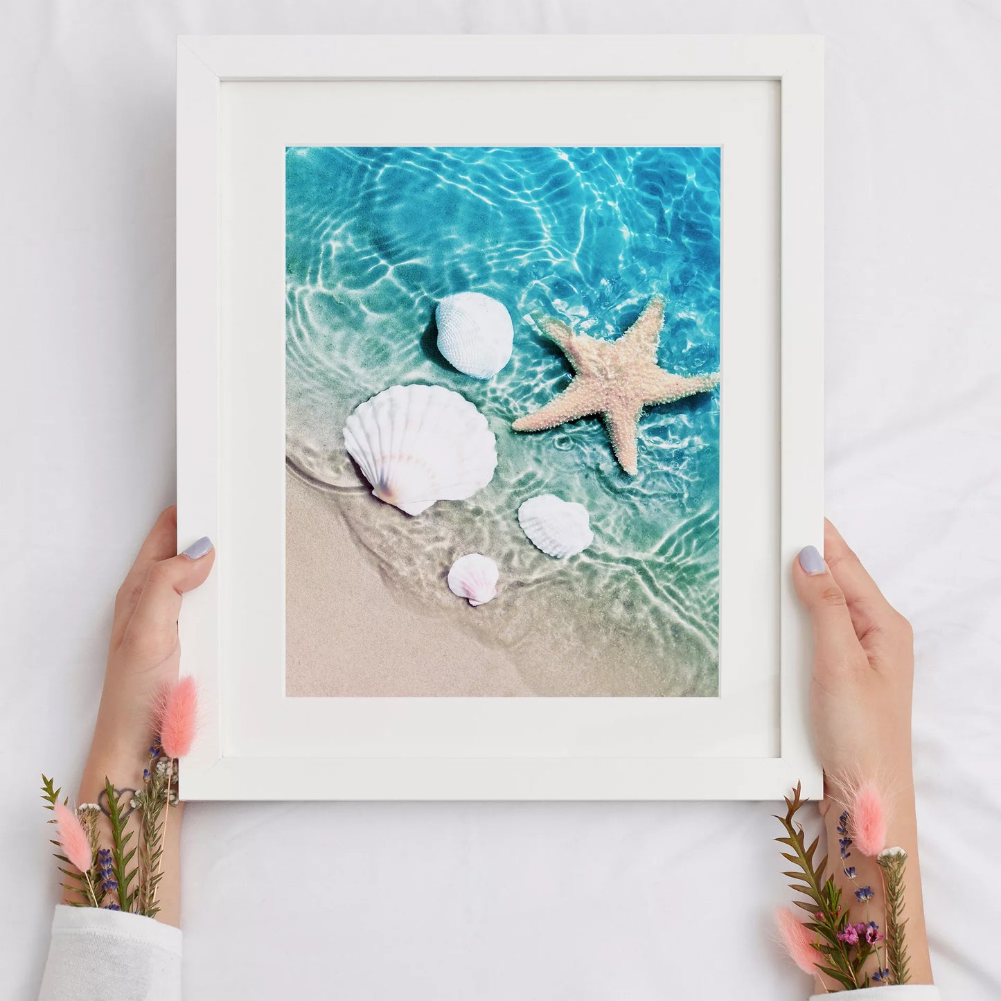 透明な青い海水とビーチに置かれた白い貝殻とヒトデのアート写真