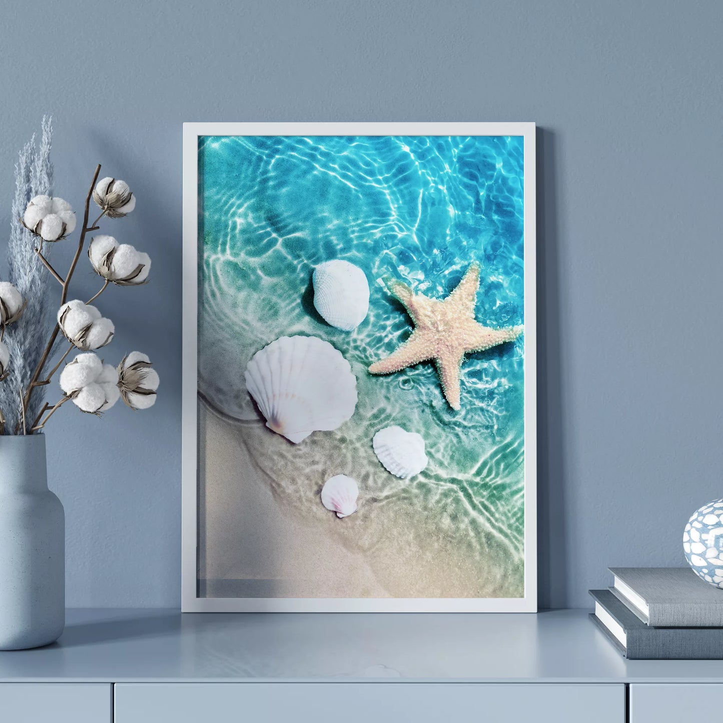 透明な青い海水とビーチに置かれた白い貝殻とヒトデのアート写真