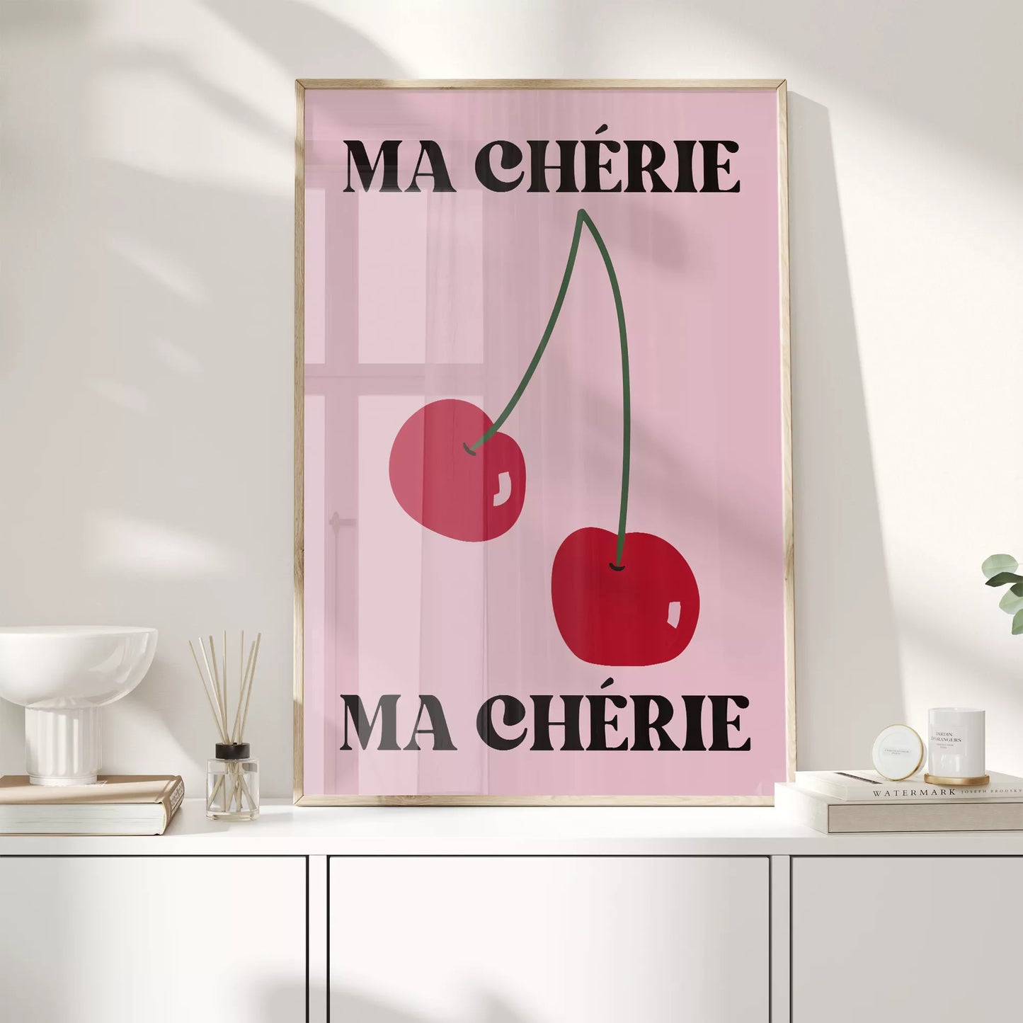 フレンチスタイルのアートポスター:ピンクの背景に赤いさくらんぼが2つ描かれ、上下に「MA CHÉRIE」の文字が黒で配置されたモダンなデザイン