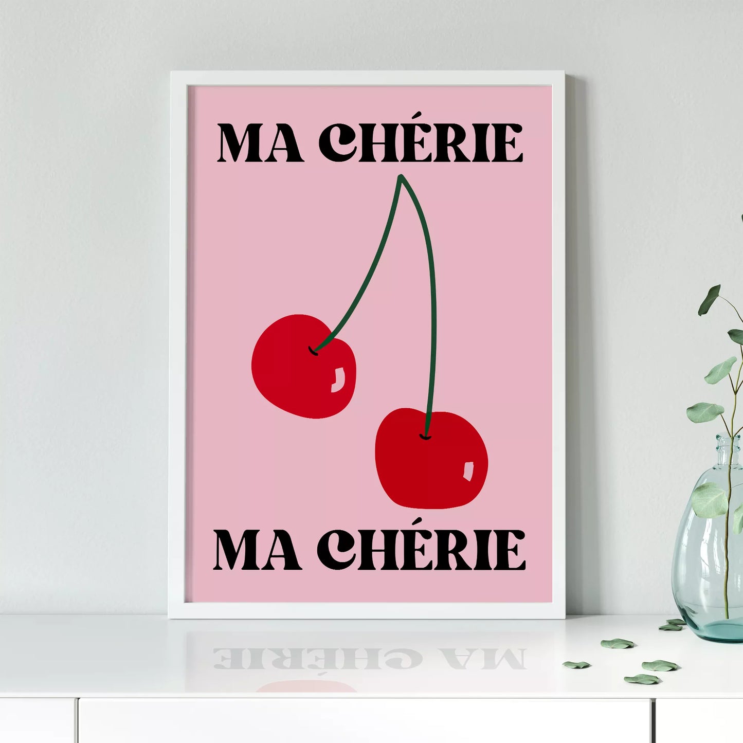 フレンチスタイルのアートポスター:ピンクの背景に赤いさくらんぼが2つ描かれ、上下に「MA CHÉRIE」の文字が黒で配置されたモダンなデザイン
