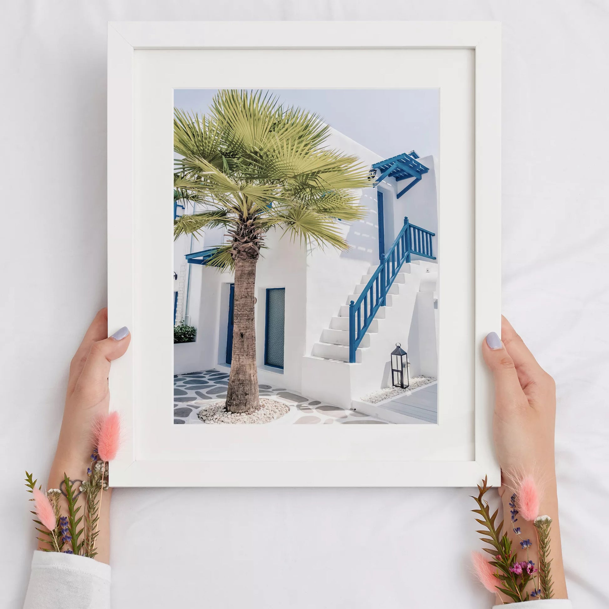 サントリーニ風の白壁と青い手すりのある階段、ヤシの木が印象的な地中海スタイルの建築
