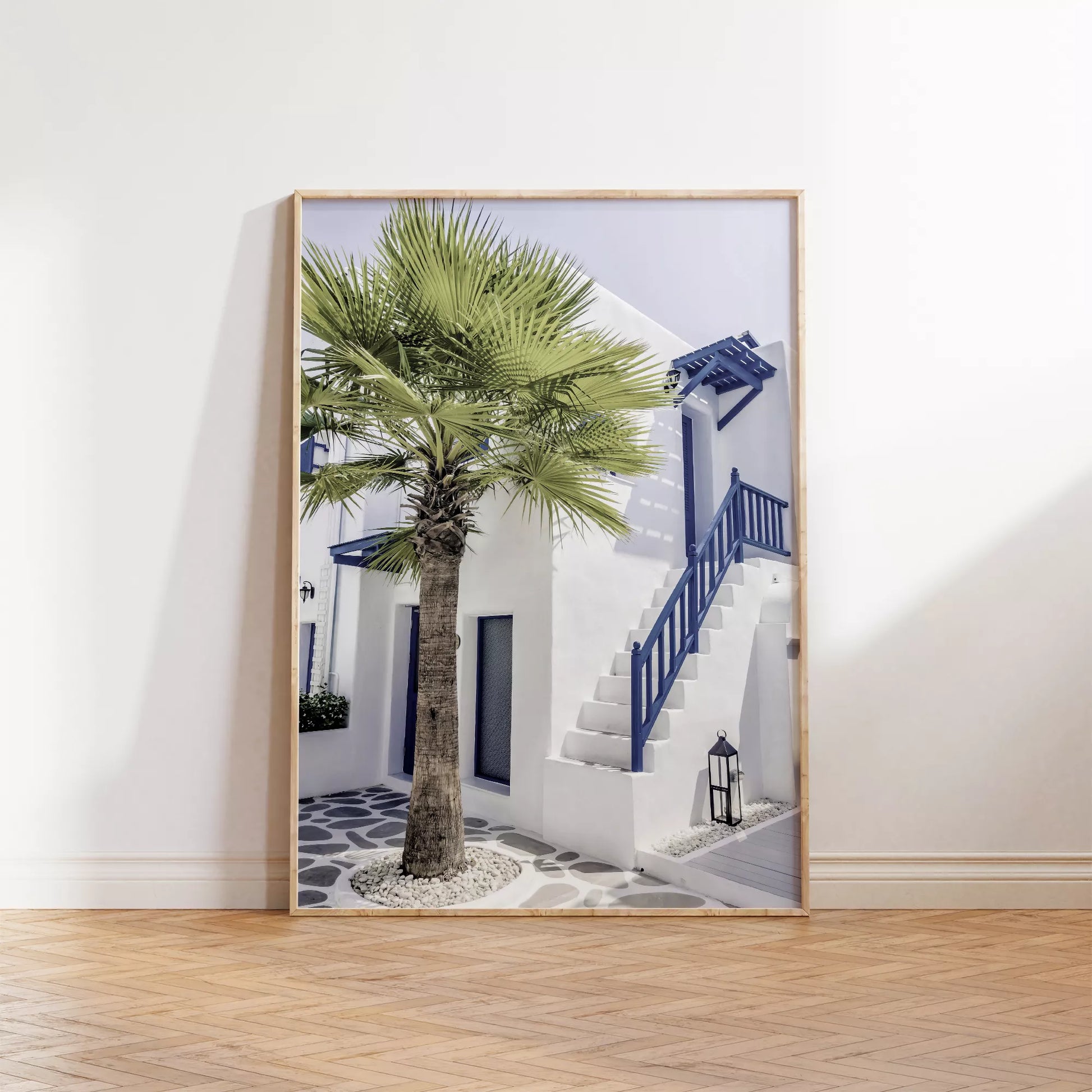 サントリーニ風の白壁と青い手すりのある階段、ヤシの木が印象的な地中海スタイルの建築