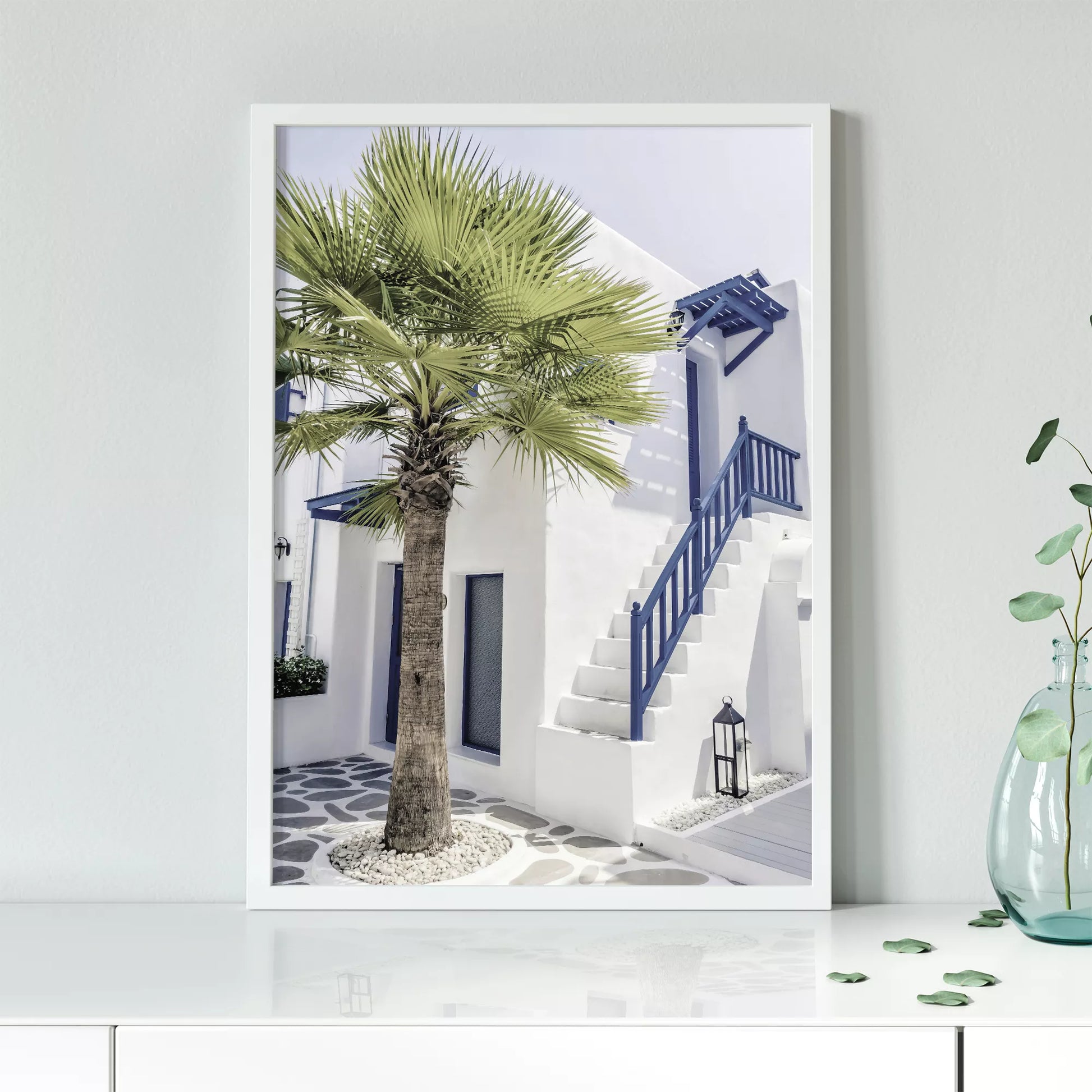 サントリーニ風の白壁と青い手すりのある階段、ヤシの木が印象的な地中海スタイルの建築