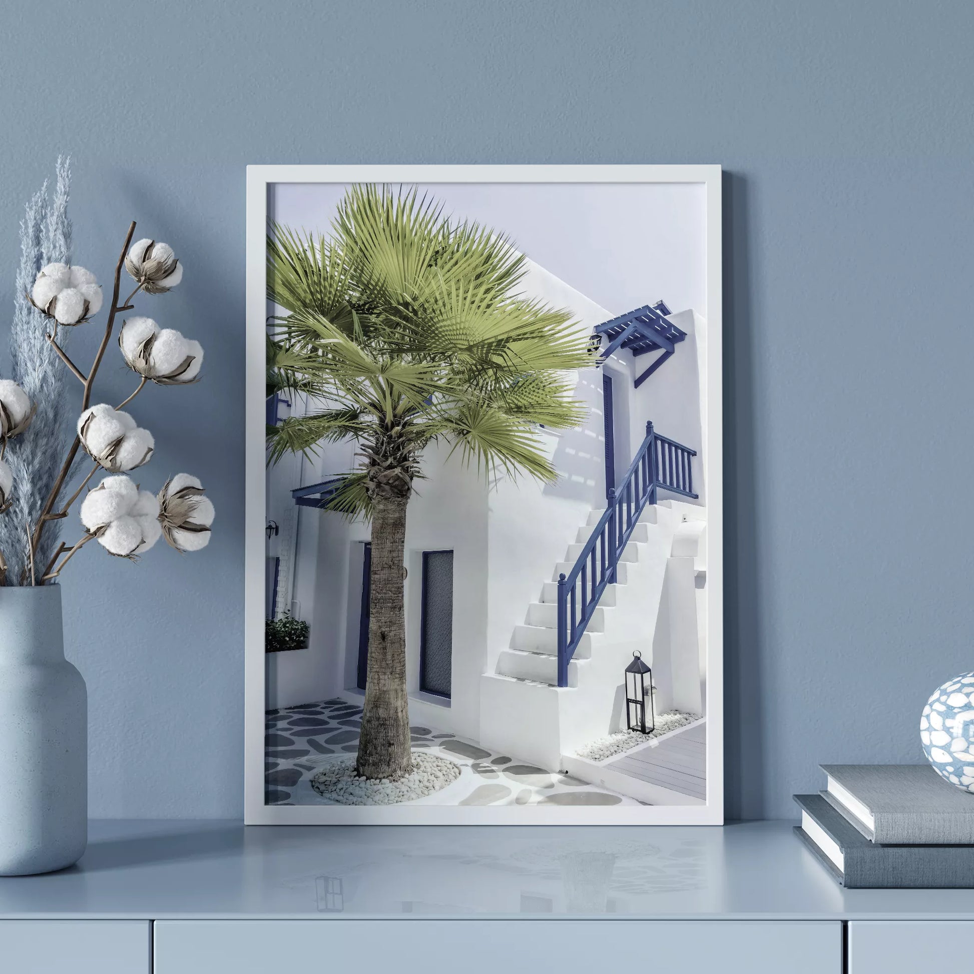 サントリーニ風の白壁と青い手すりのある階段、ヤシの木が印象的な地中海スタイルの建築