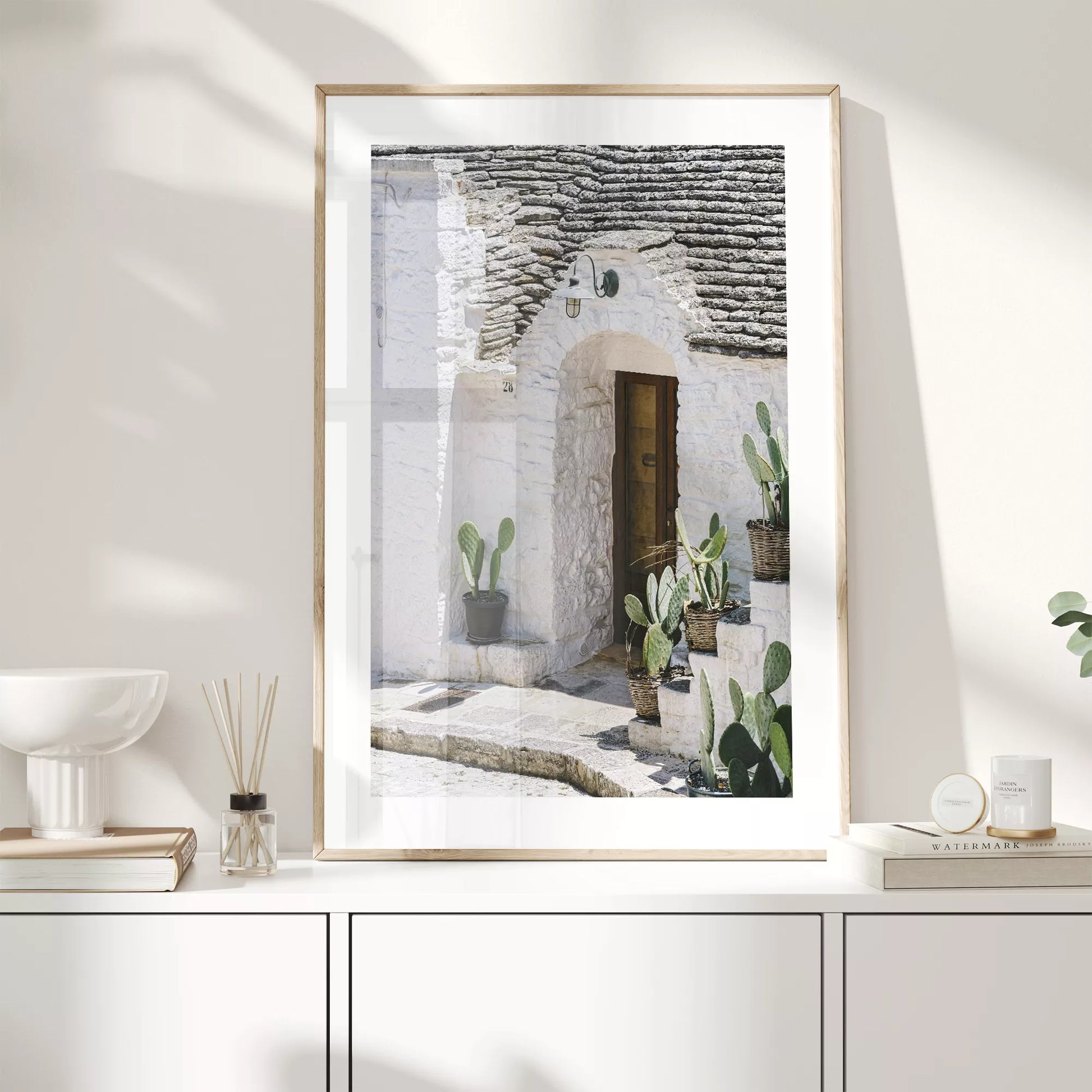 白壁の家の木製ドアとサボテンが飾られた地中海風の玄関口