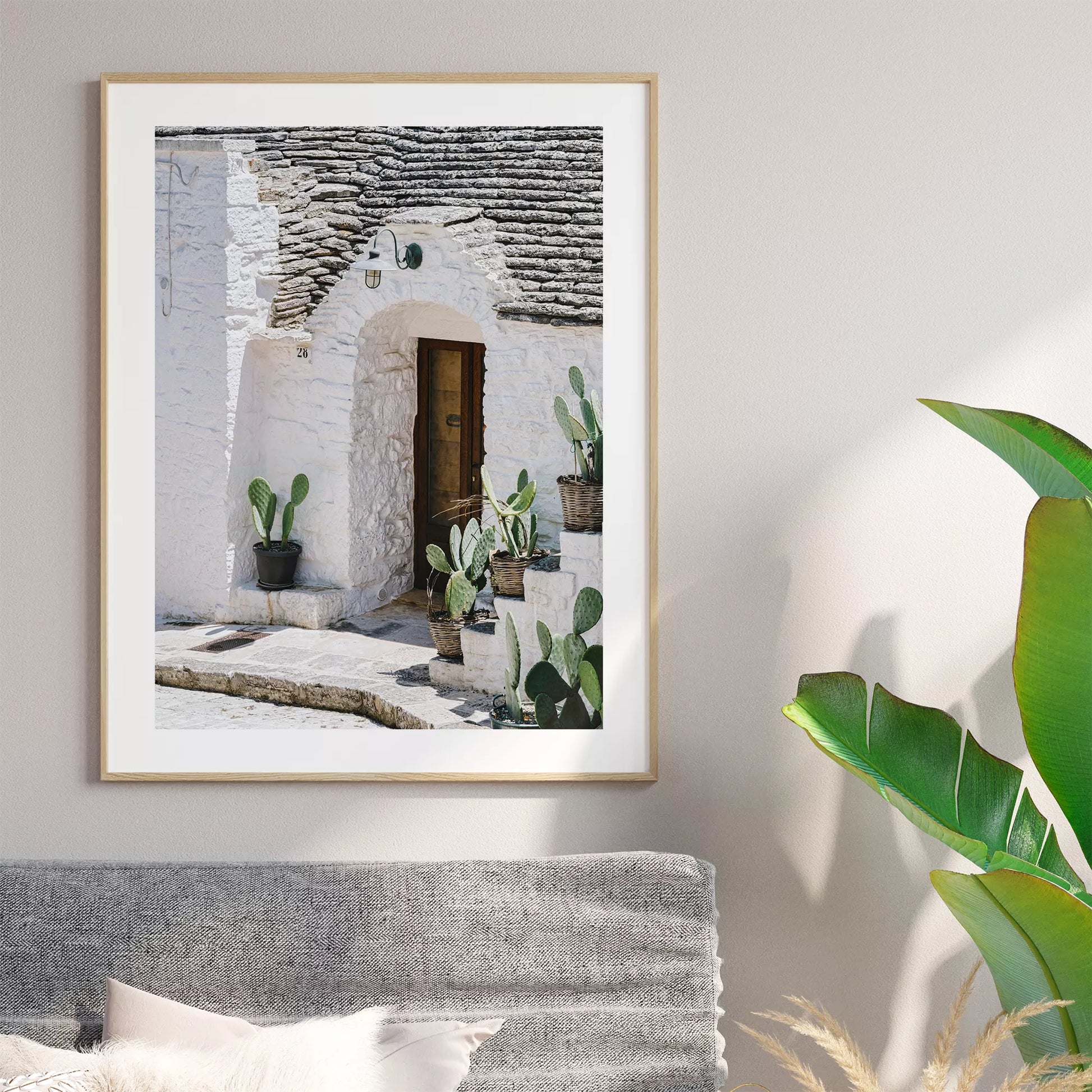 白壁の家の木製ドアとサボテンが飾られた地中海風の玄関口