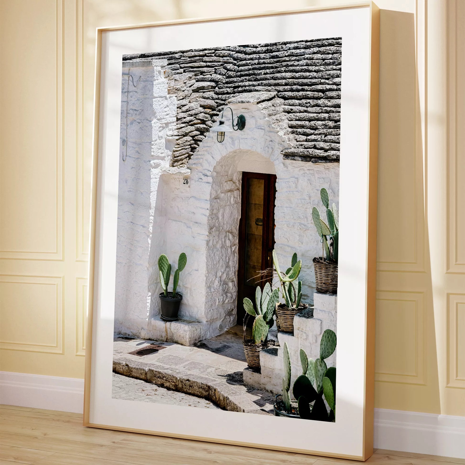 白壁の家の木製ドアとサボテンが飾られた地中海風の玄関口