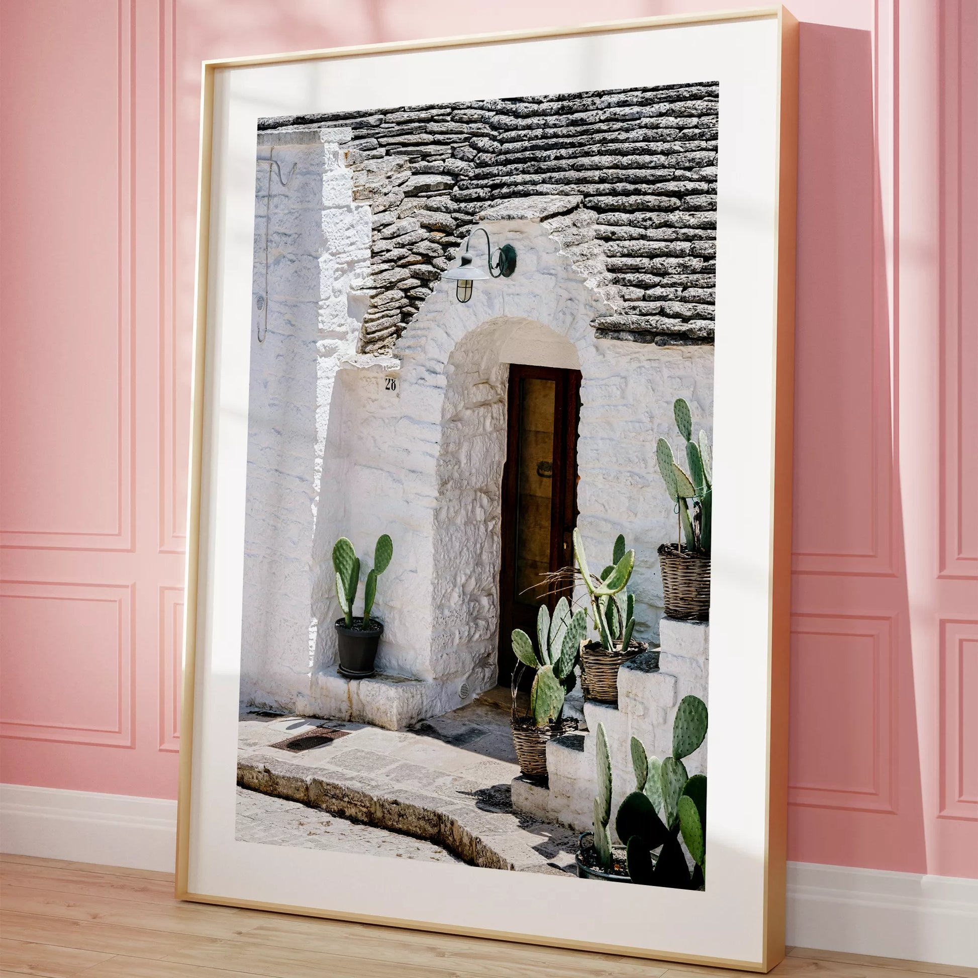 白壁の家の木製ドアとサボテンが飾られた地中海風の玄関口