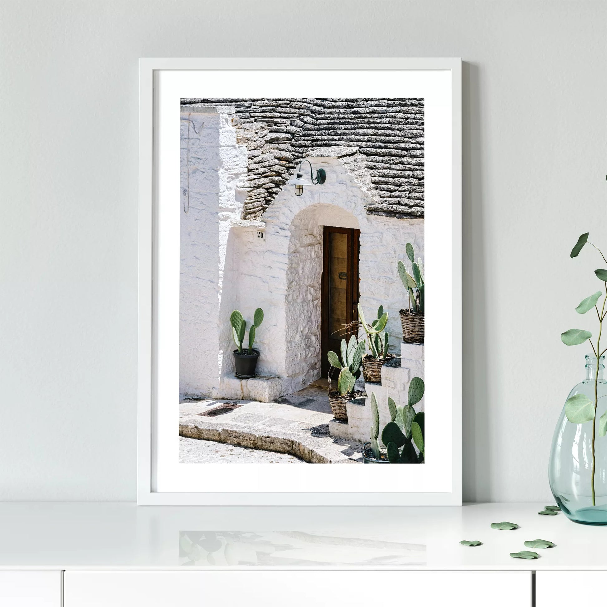 白壁の家の木製ドアとサボテンが飾られた地中海風の玄関口