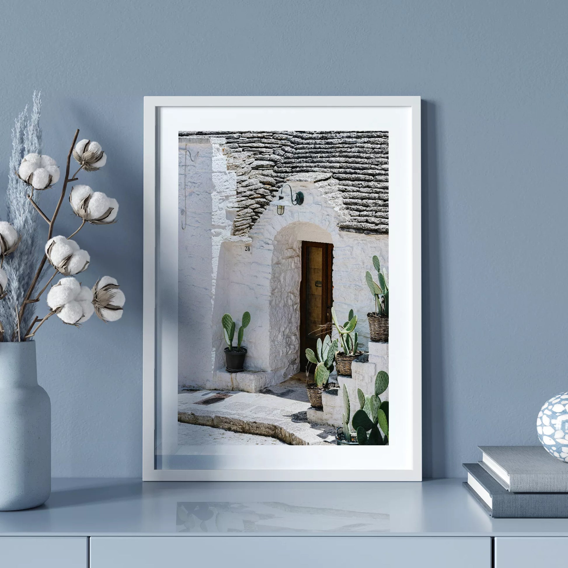 白壁の家の木製ドアとサボテンが飾られた地中海風の玄関口