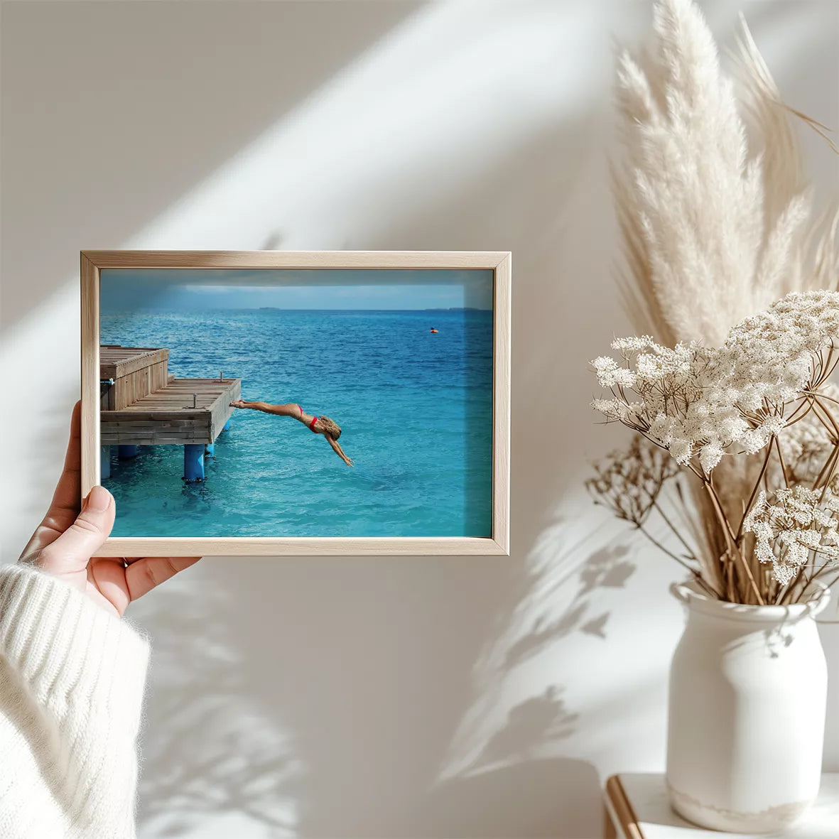 青い海に木製デッキからダイビングする爽快な瞬間