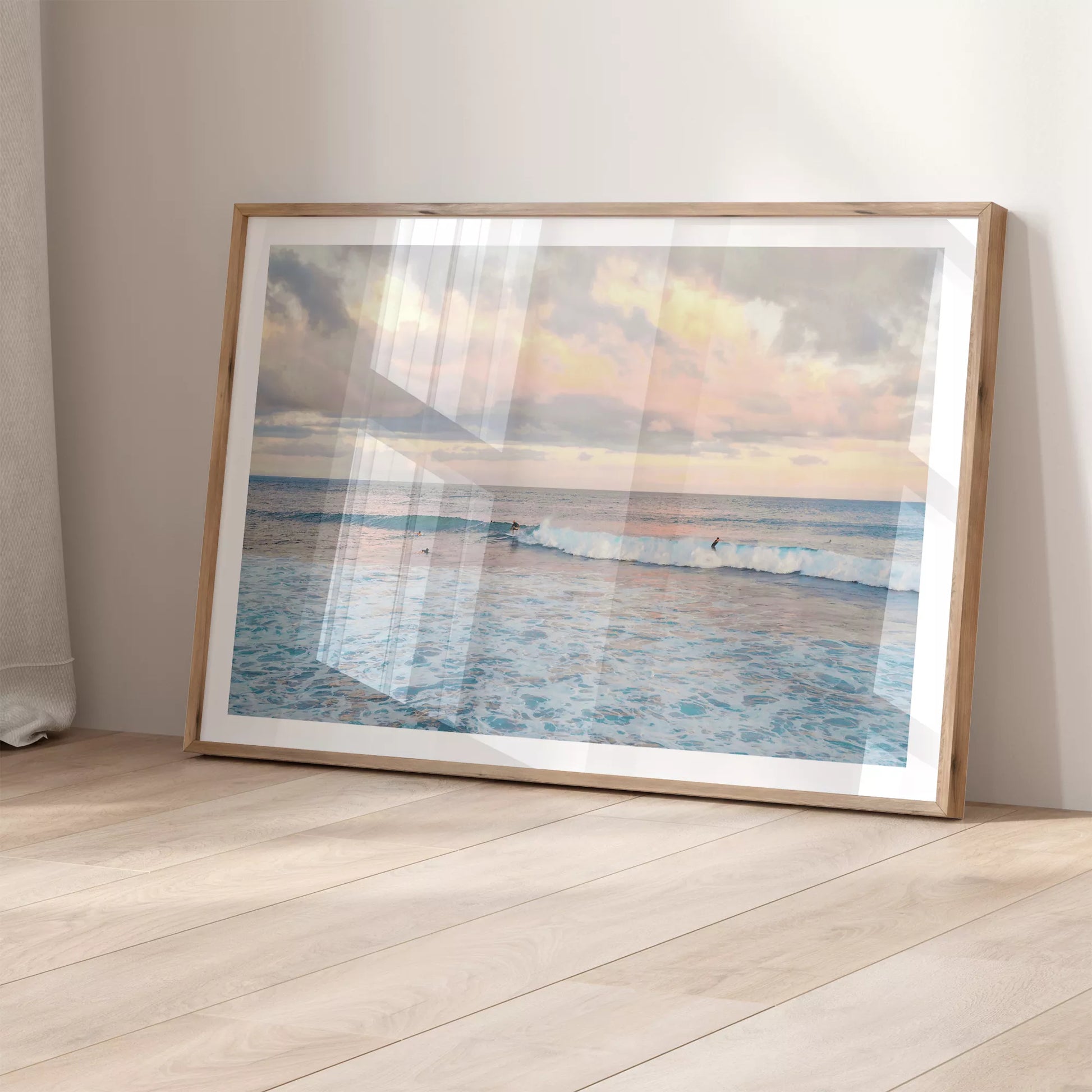 パステルピンクの夕暮れ空とターコイズブルーの波でサーフィンを楽しむ海景色