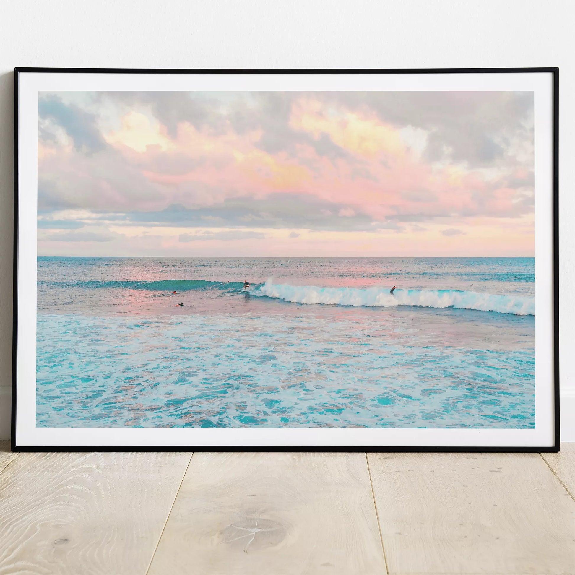 パステルピンクの夕暮れ空とターコイズブルーの波でサーフィンを楽しむ海景色