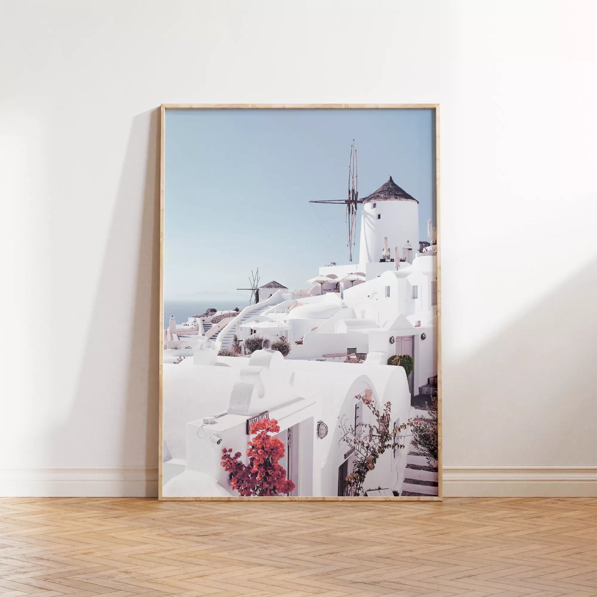 サントリーニ島の白壁の建物と風車、赤いブーゲンビリアが咲く地中海風景