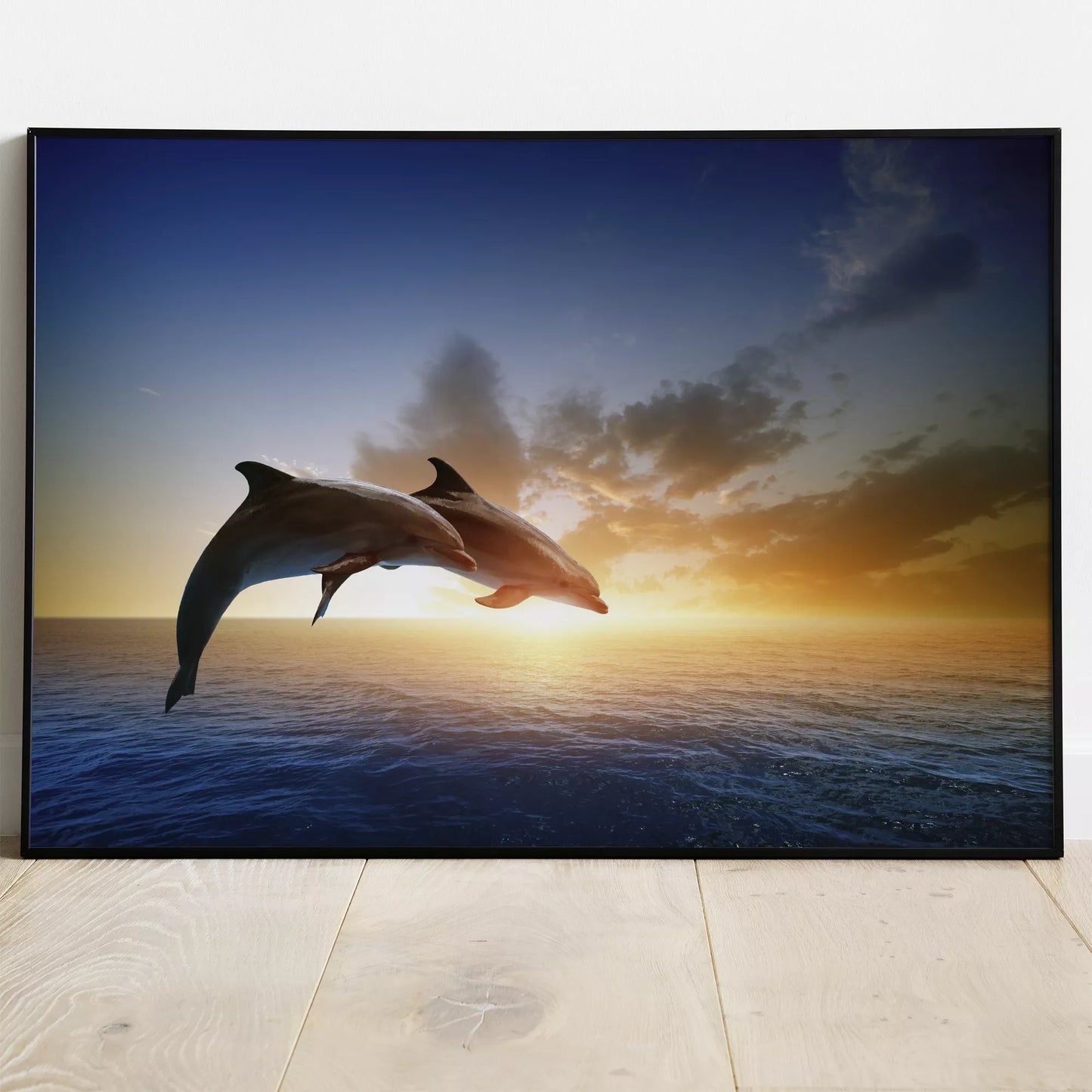 夕陽に向かってジャンプする2頭のイルカのシルエット