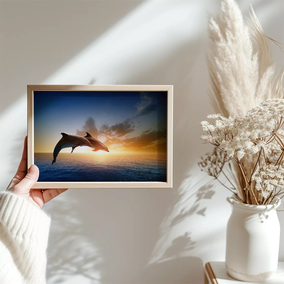 夕陽に向かってジャンプする2頭のイルカのシルエット