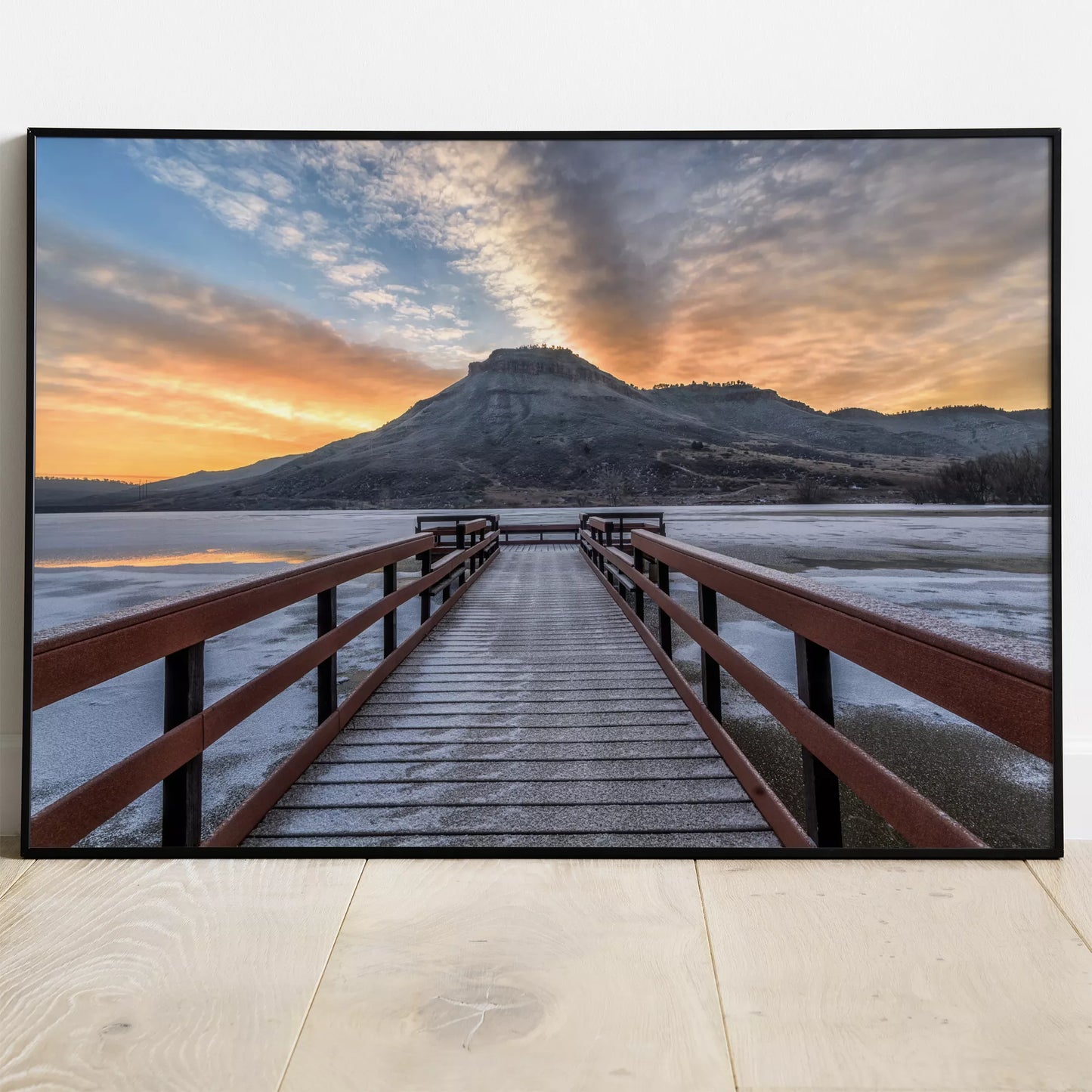 凍った湖に伸びる赤い桟橋と夕暮れの山の風景