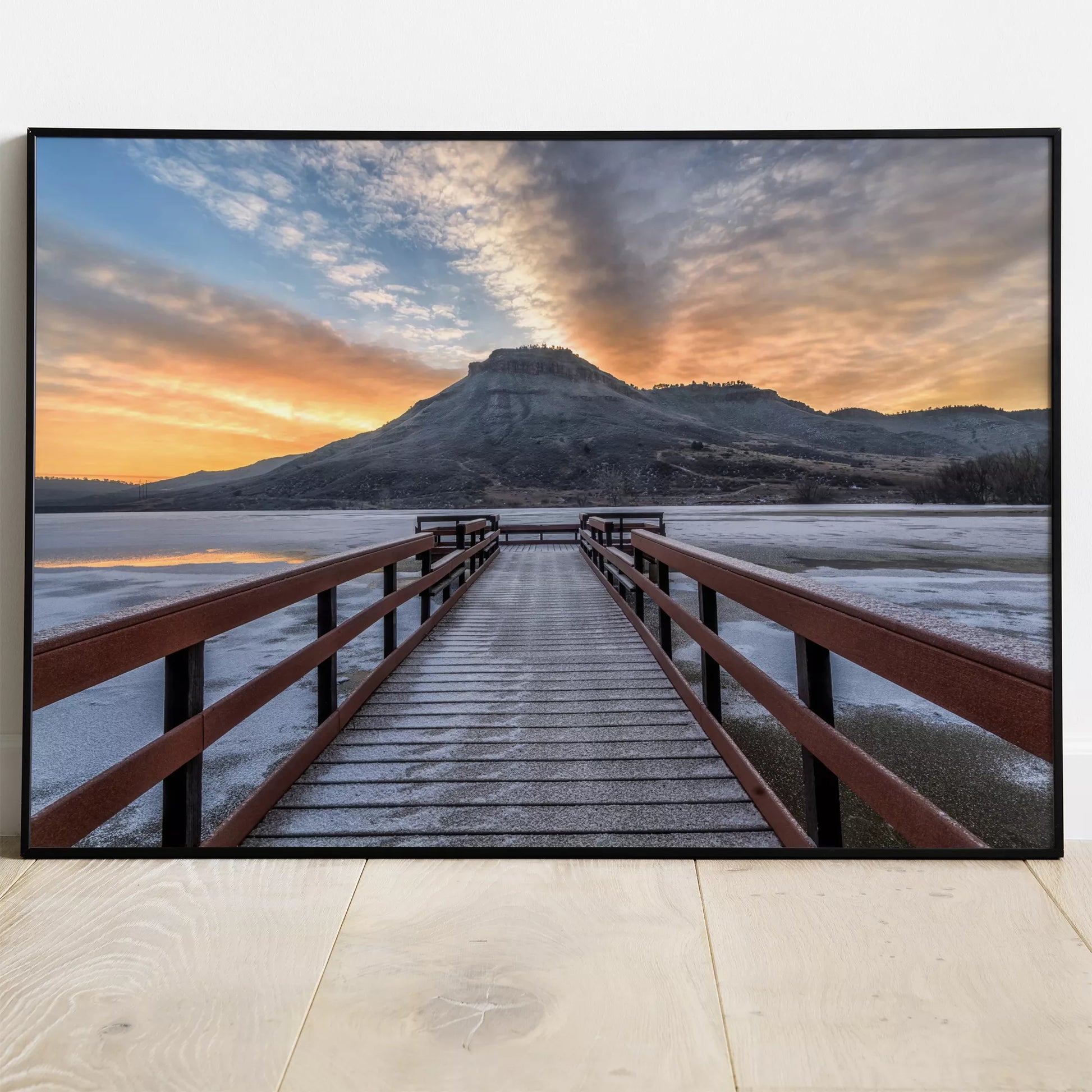 凍った湖に伸びる赤い桟橋と夕暮れの山の風景