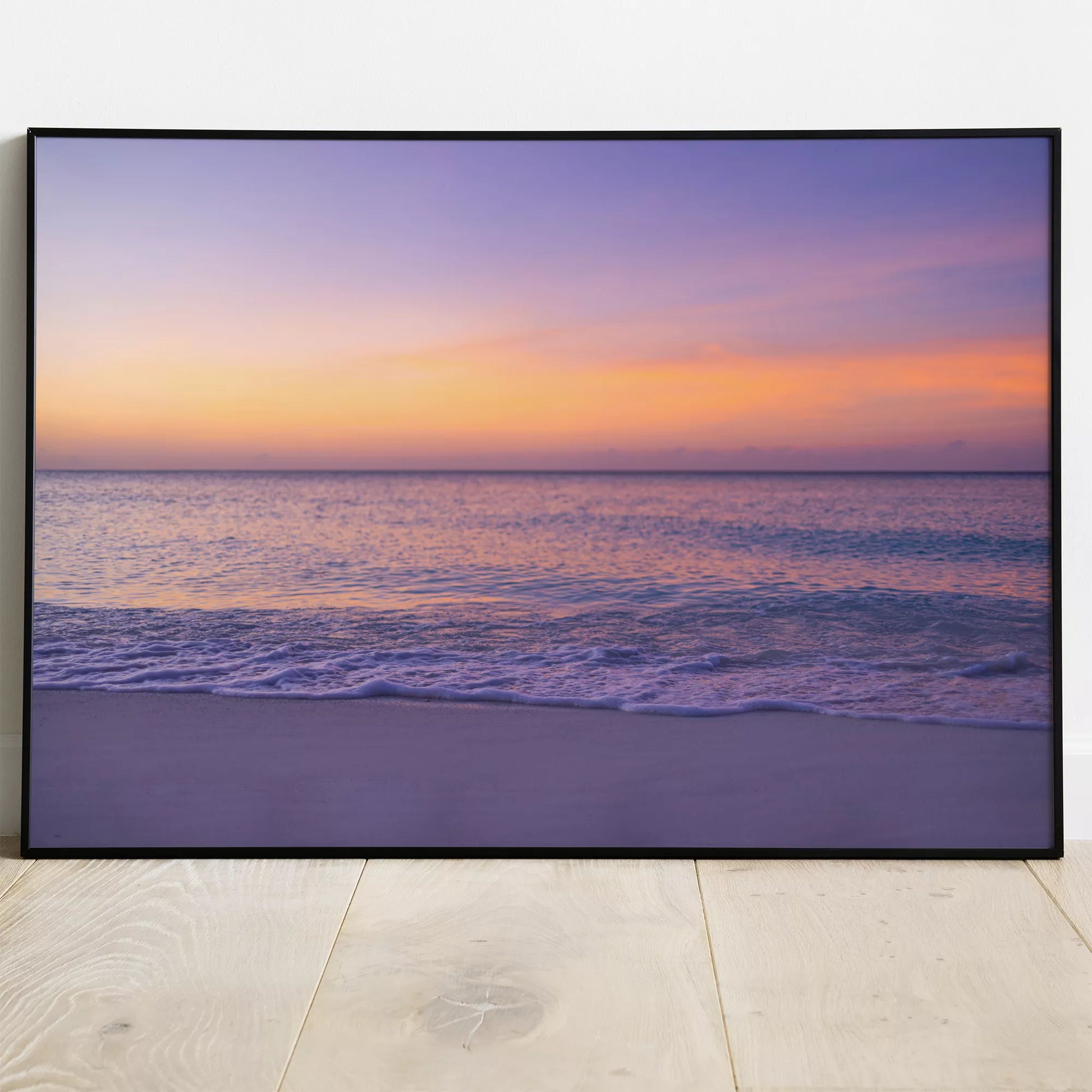 紫とオレンジの夕焼けに染まる穏やかな海の風景