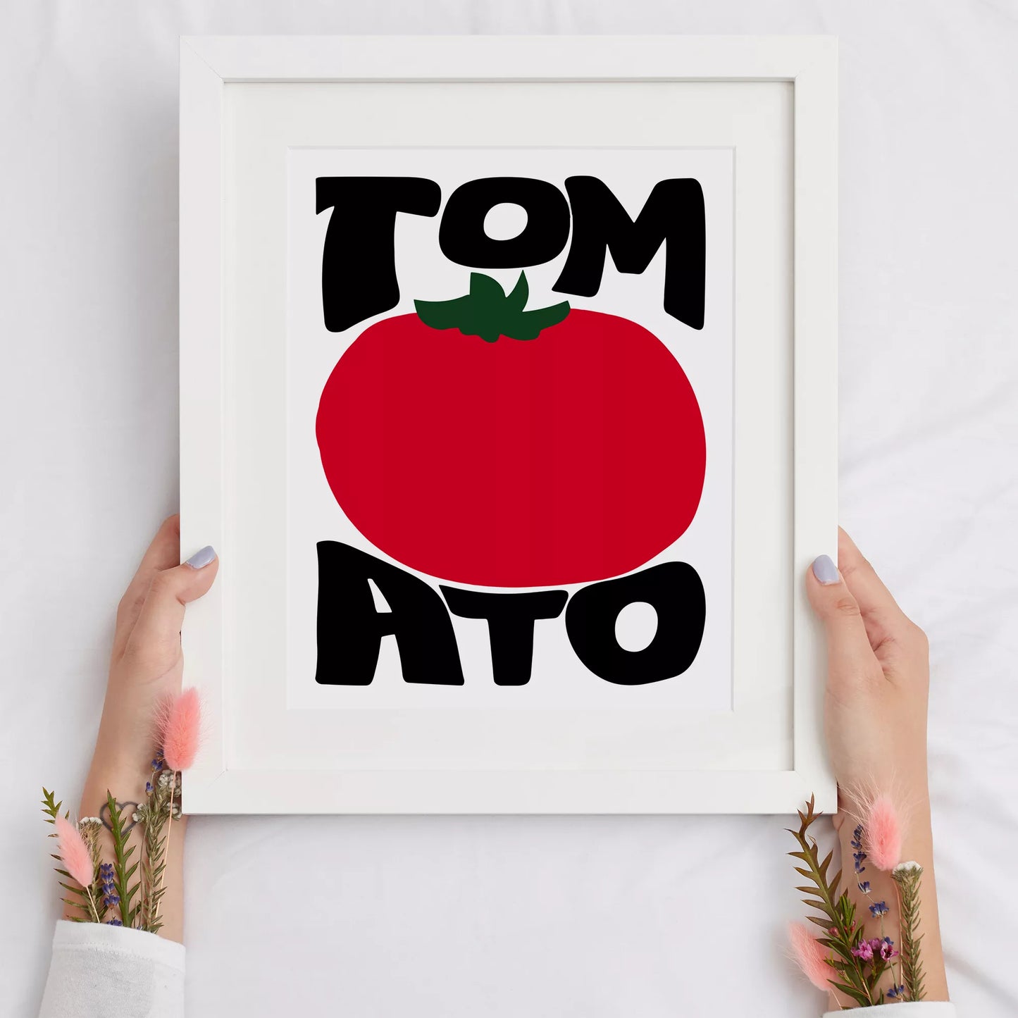 白地にモダンな黒字で「TOMATO」の文字を「TOM」と「ATO」に分け、その間に大きな赤いトマトのイラストをあしらったミニマルなアートプリント。緑の葉がアクセントとなり、シンプルながらインパクトのあるデザイン。