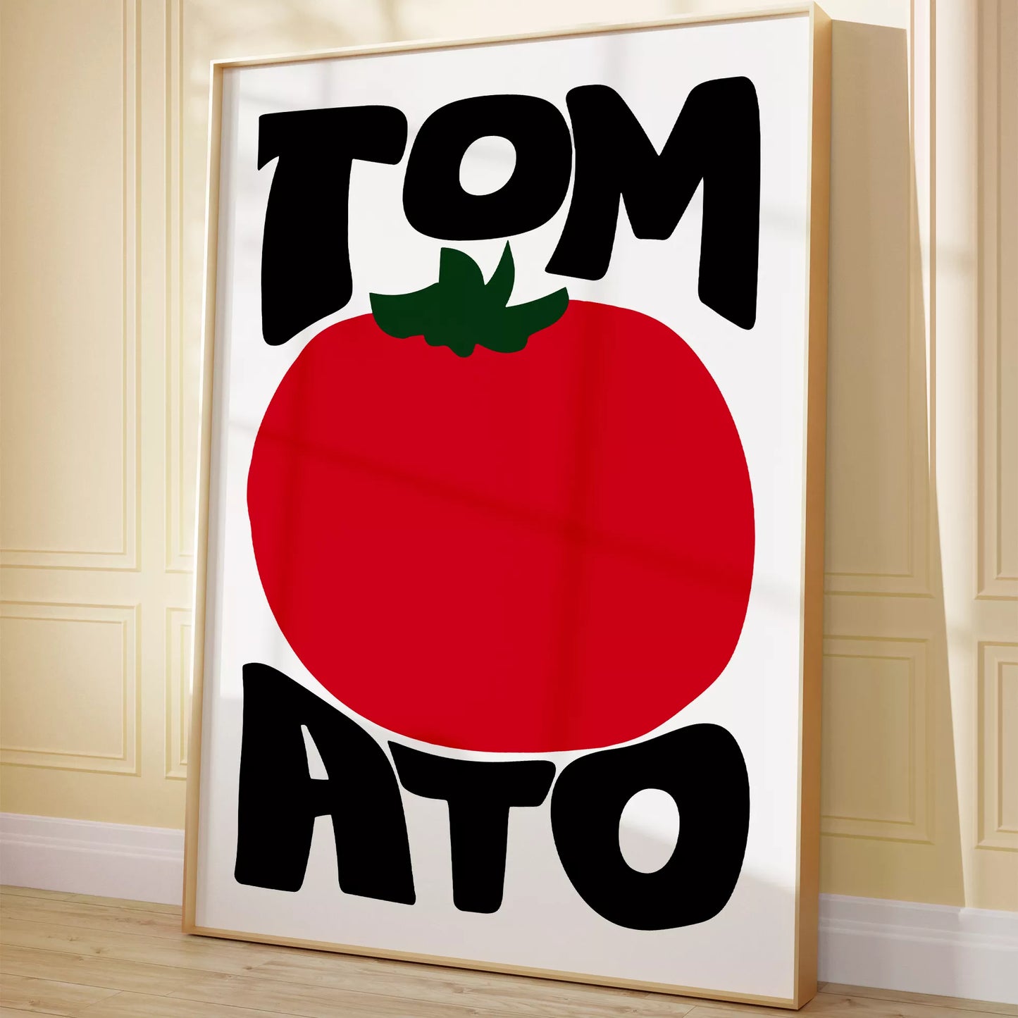 白地にモダンな黒字で「TOMATO」の文字を「TOM」と「ATO」に分け、その間に大きな赤いトマトのイラストをあしらったミニマルなアートプリント。緑の葉がアクセントとなり、シンプルながらインパクトのあるデザイン。